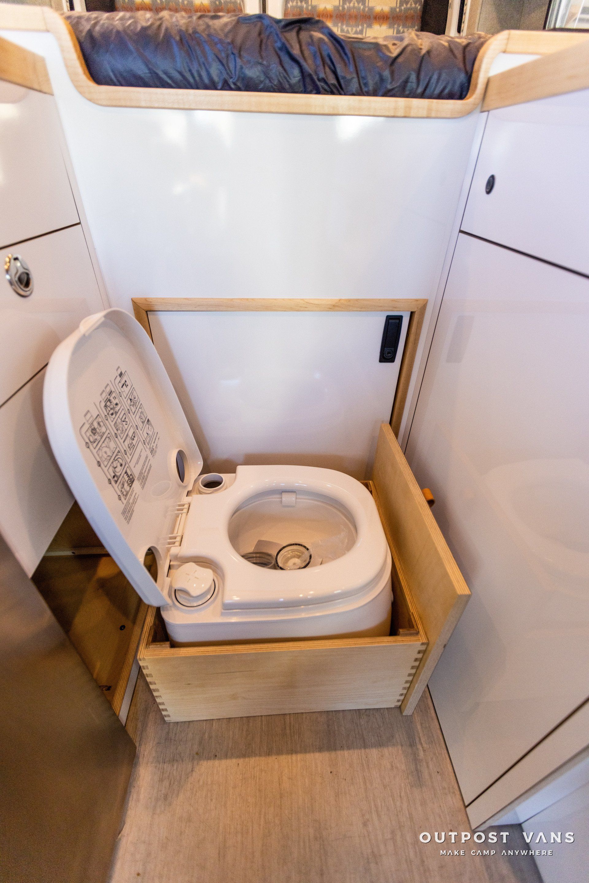 a toilet is sitting in a wooden box in a bathroom .