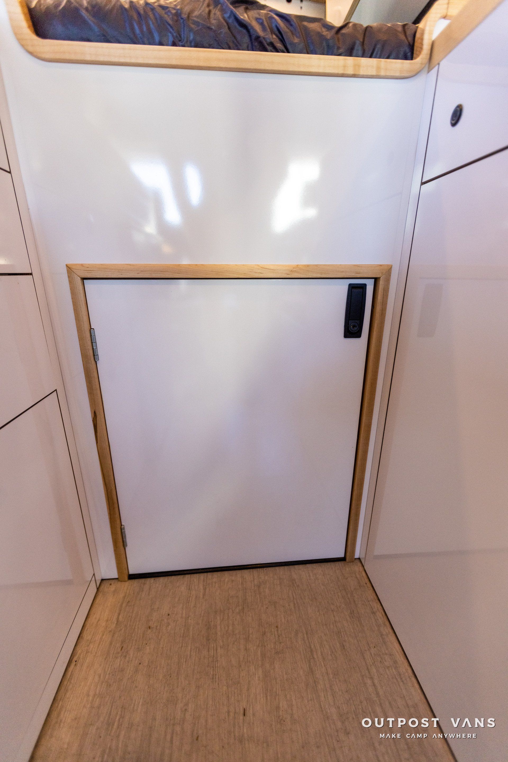 a white door in a room with a bed underneath it