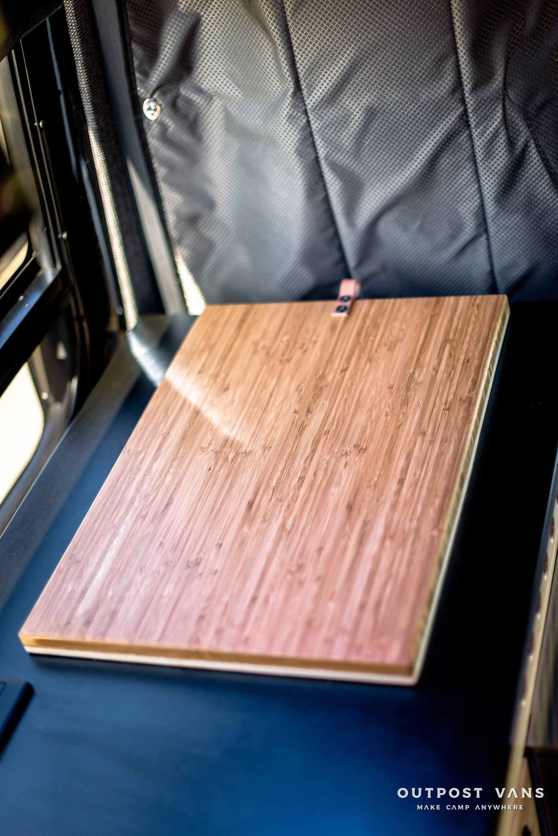 A wooden table is sitting in the back of a van.