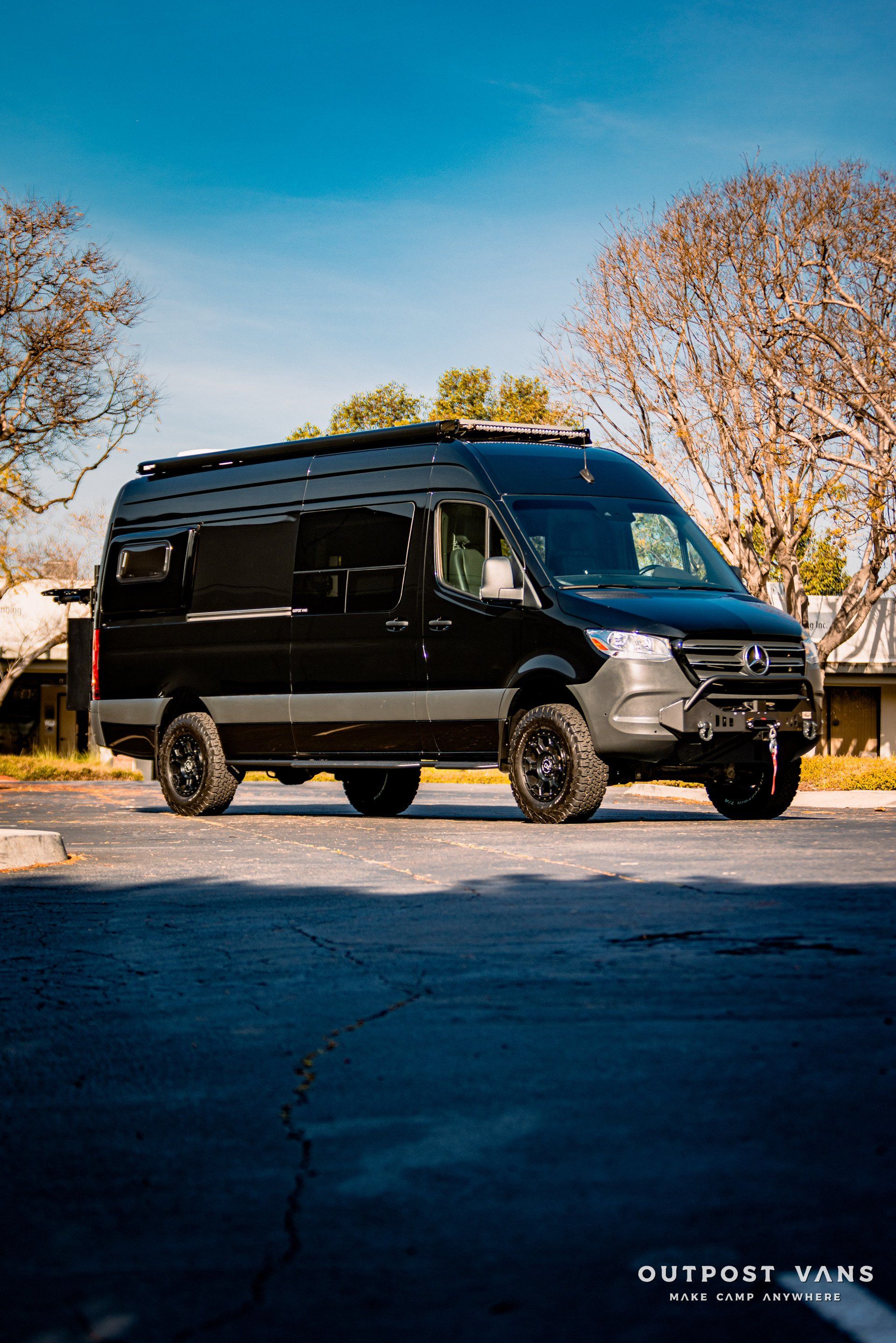 A black van is parked in a parking lot.