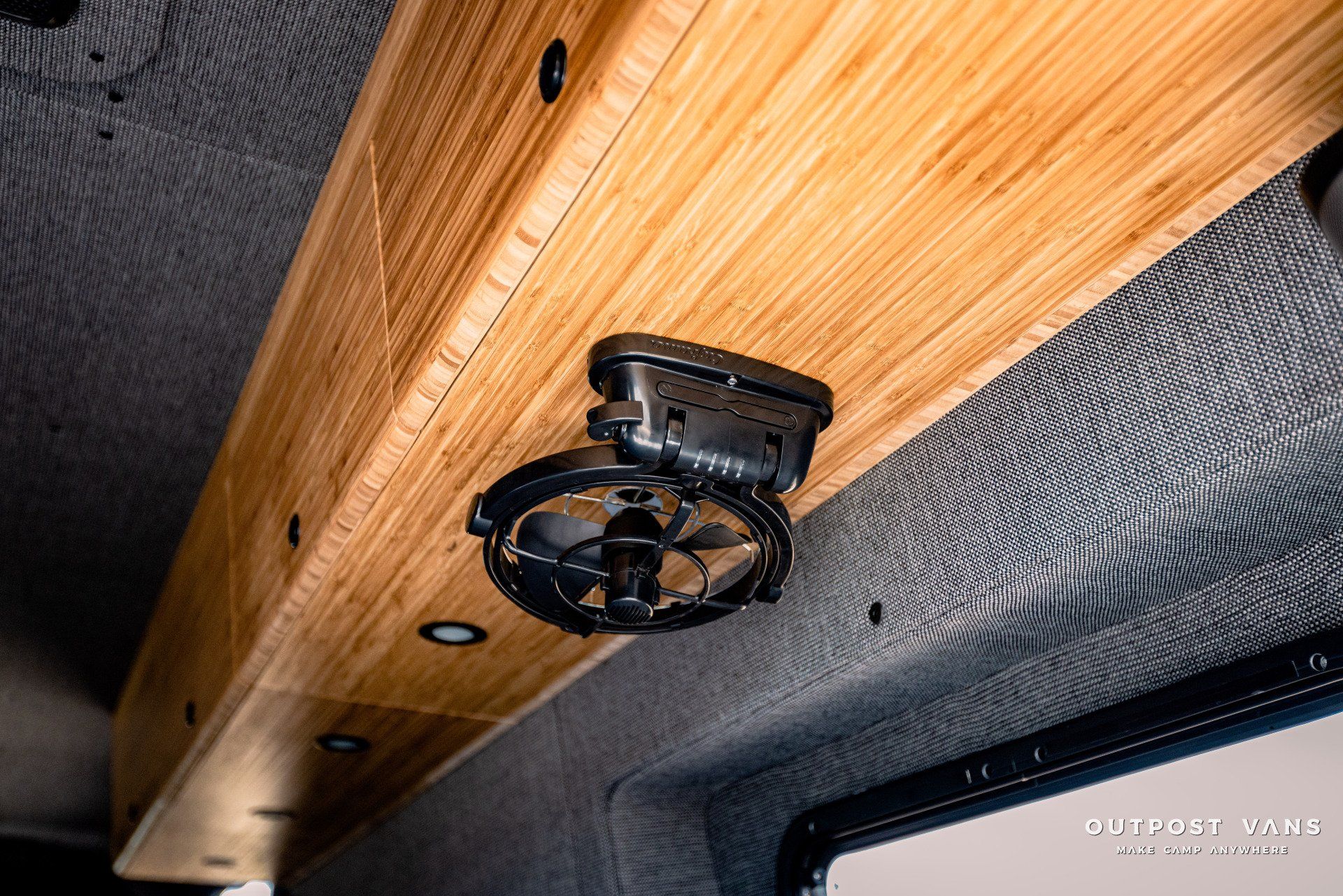 A fan is mounted to the ceiling of a van.