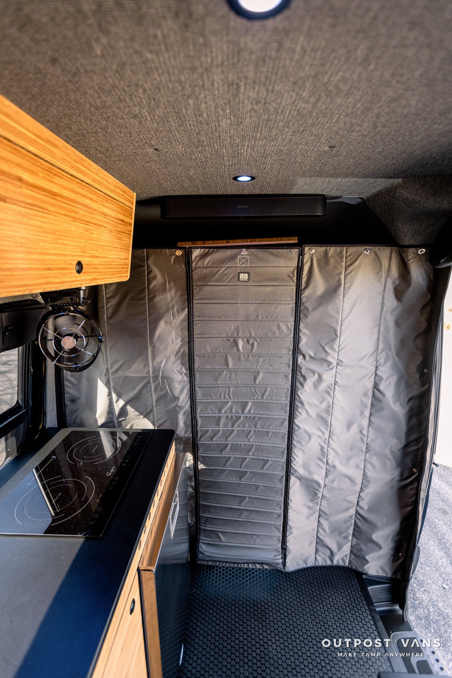 A kitchen in a van with a brick wall and a door.