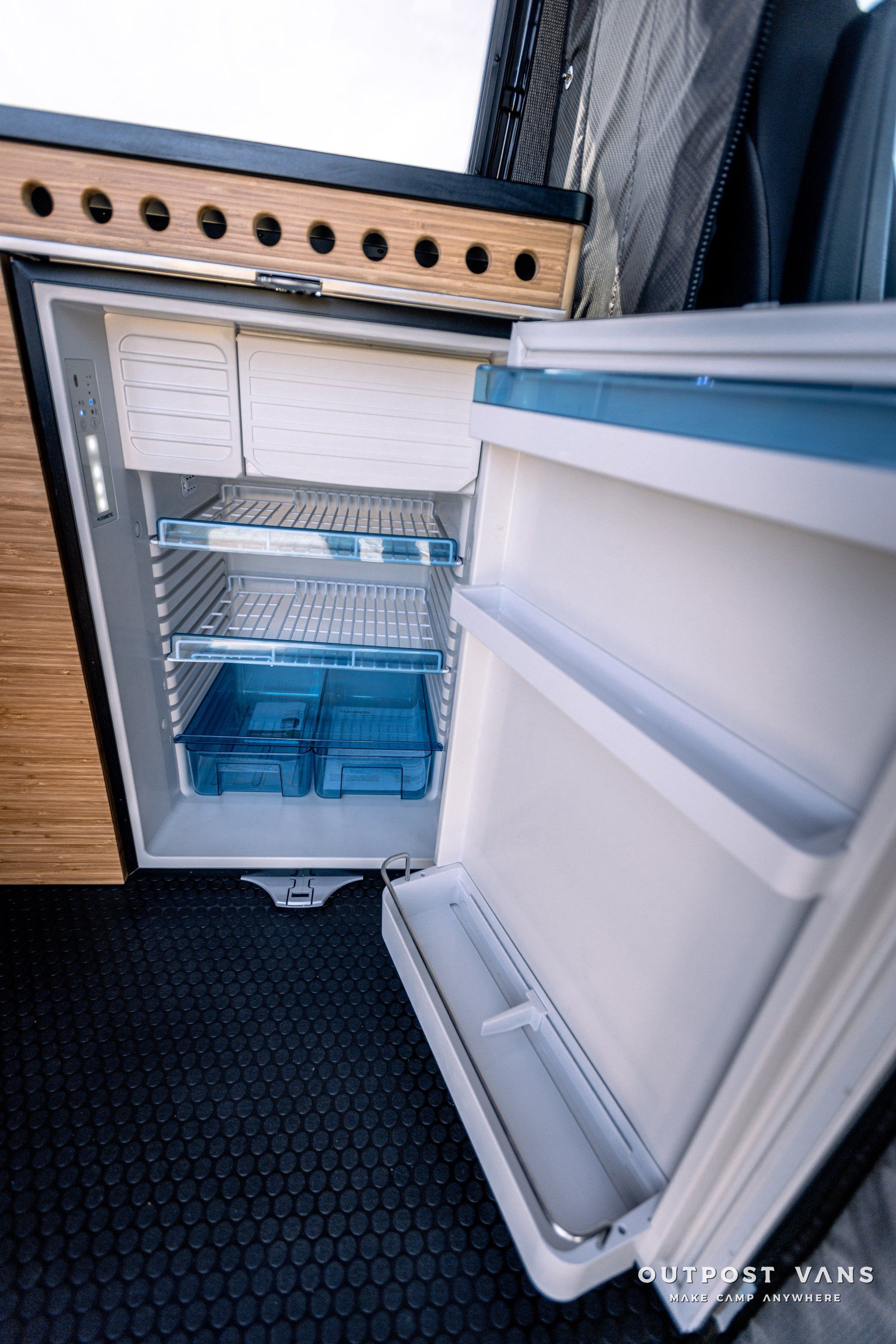 A small refrigerator with the door open in a camper van.