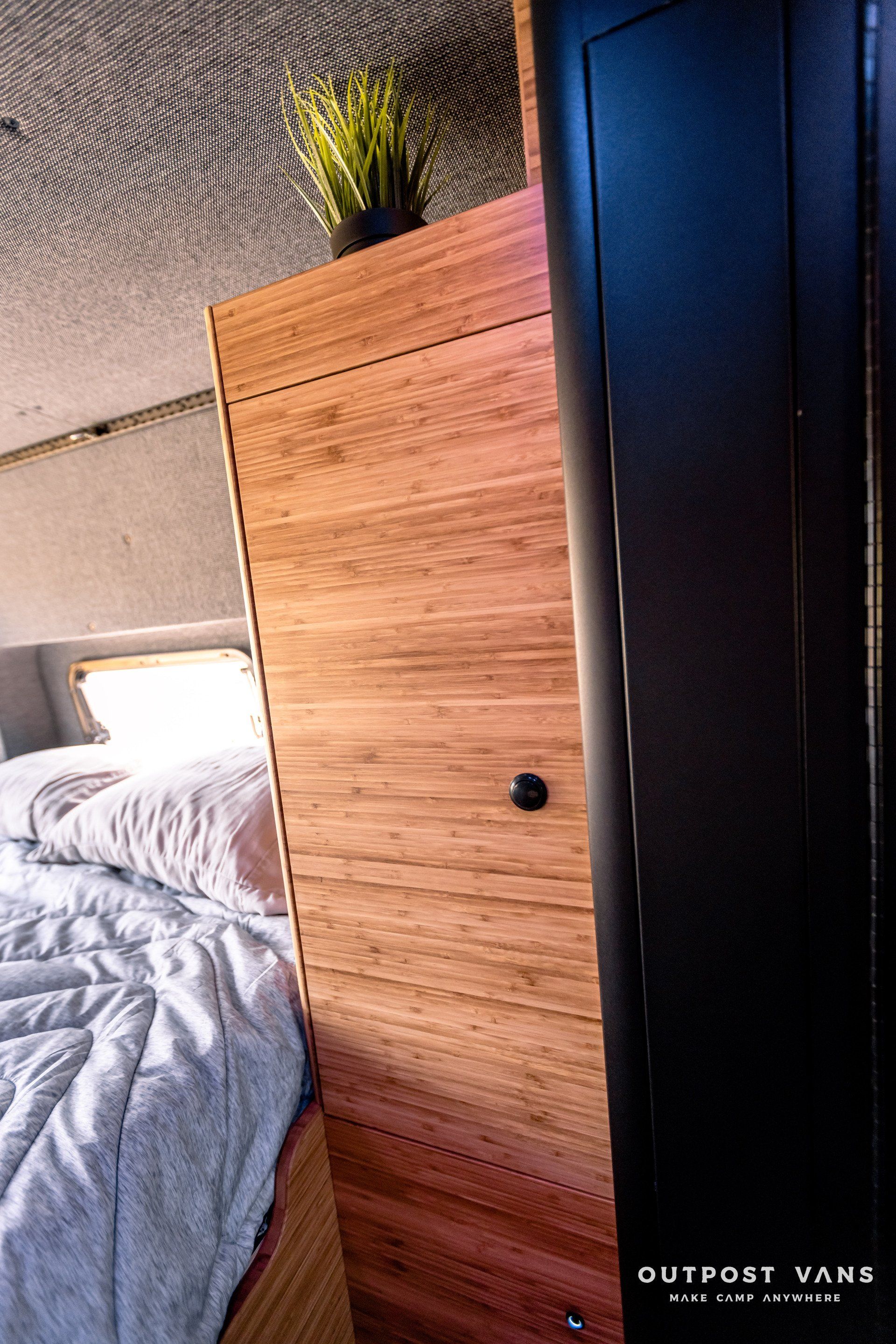 A bedroom with a bed and a wooden cabinet.