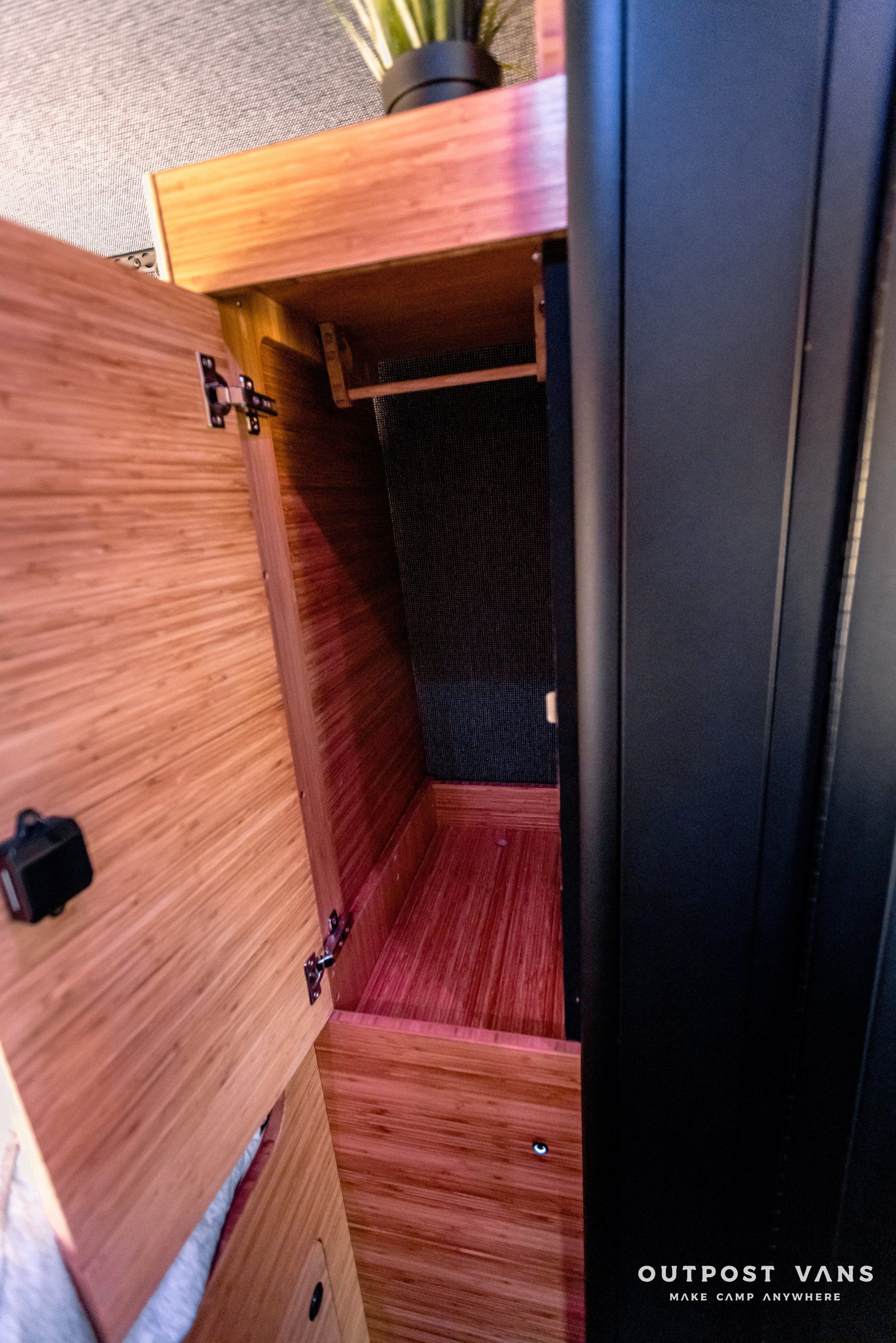 A wooden cabinet with the door open and a drawer inside of it.
