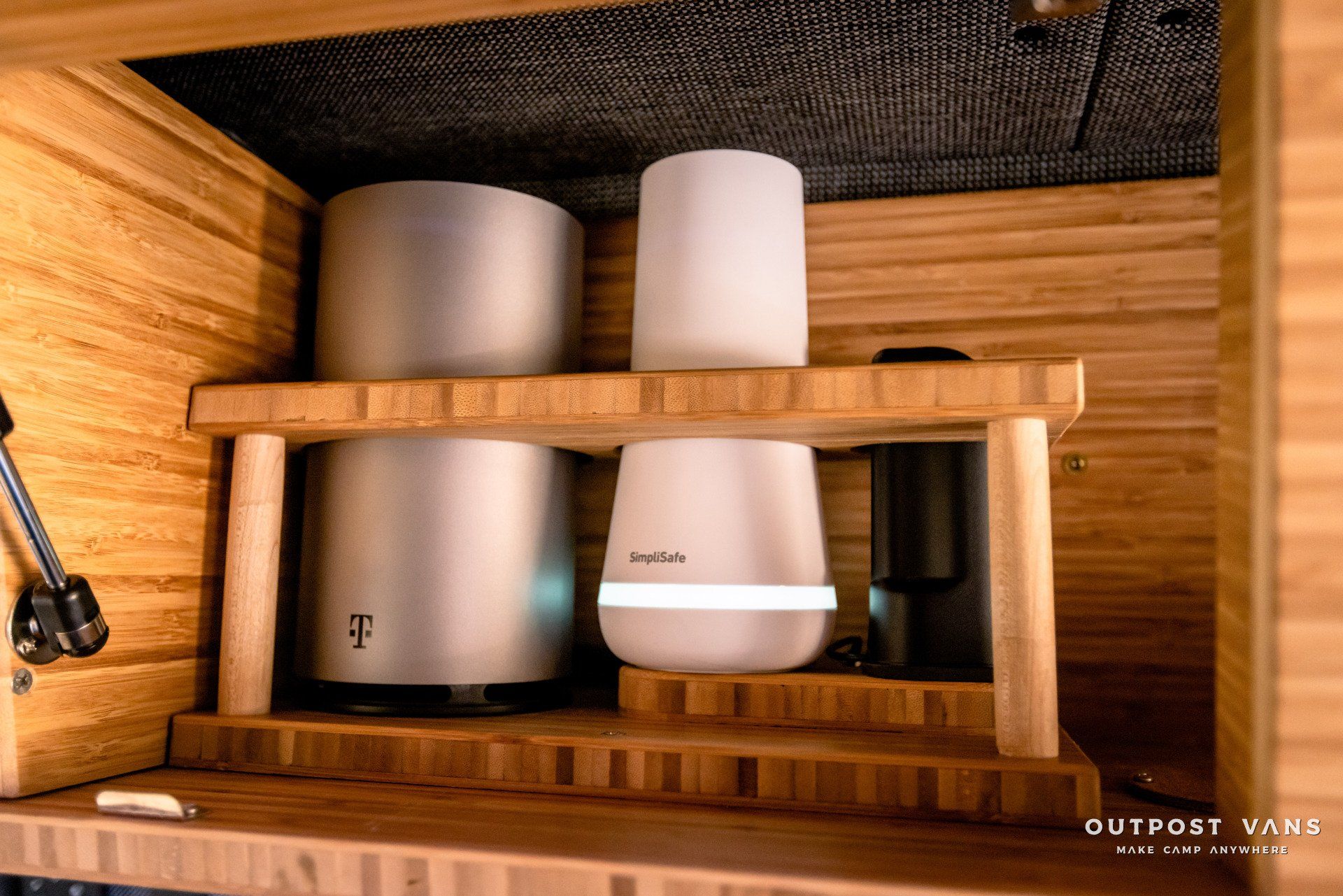 Two t mobile routers are sitting on a wooden shelf