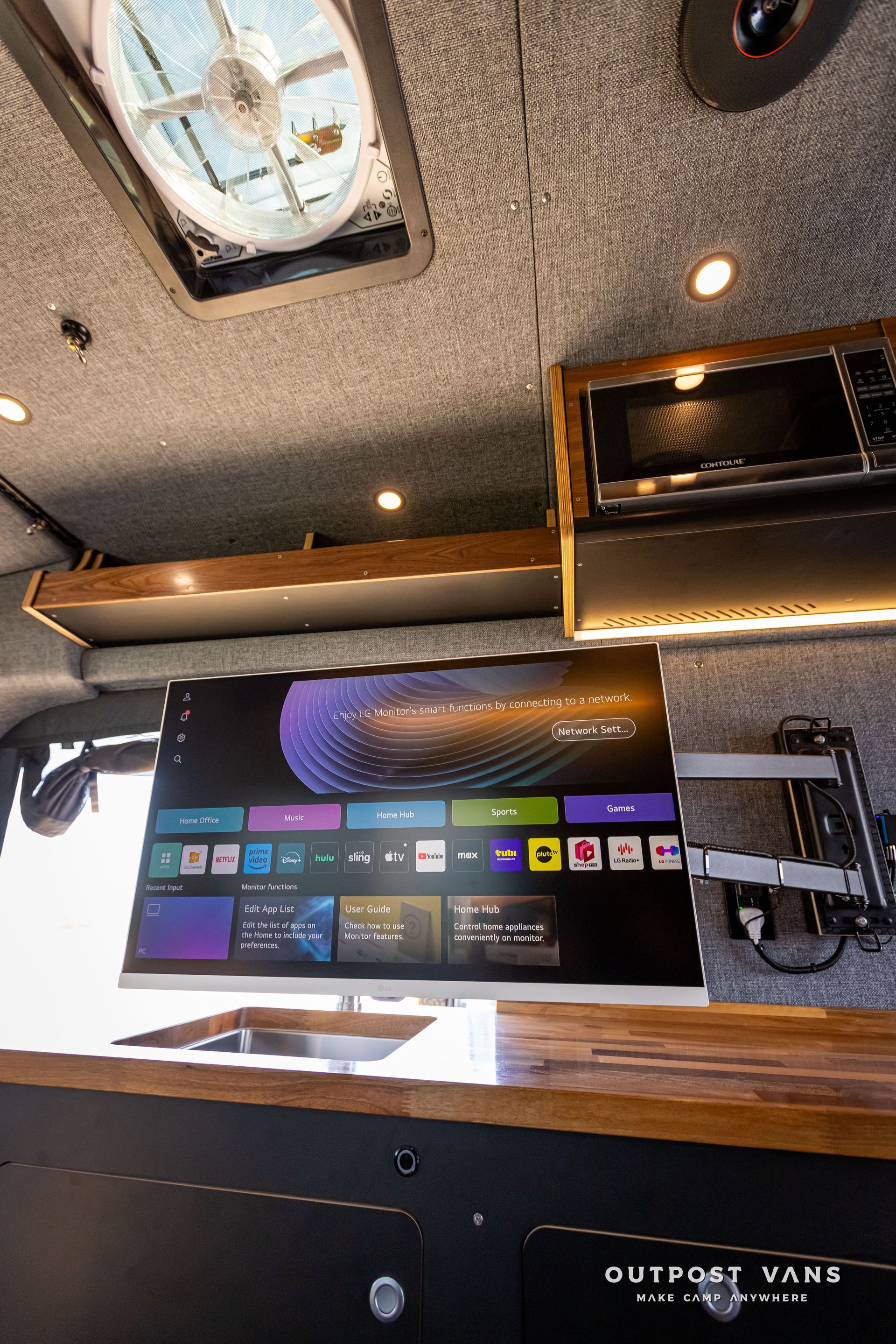 Outpost Vans custom built camper van Ford Transit 148 AWD. A ceiling fan is hanging from the ceiling of a van.