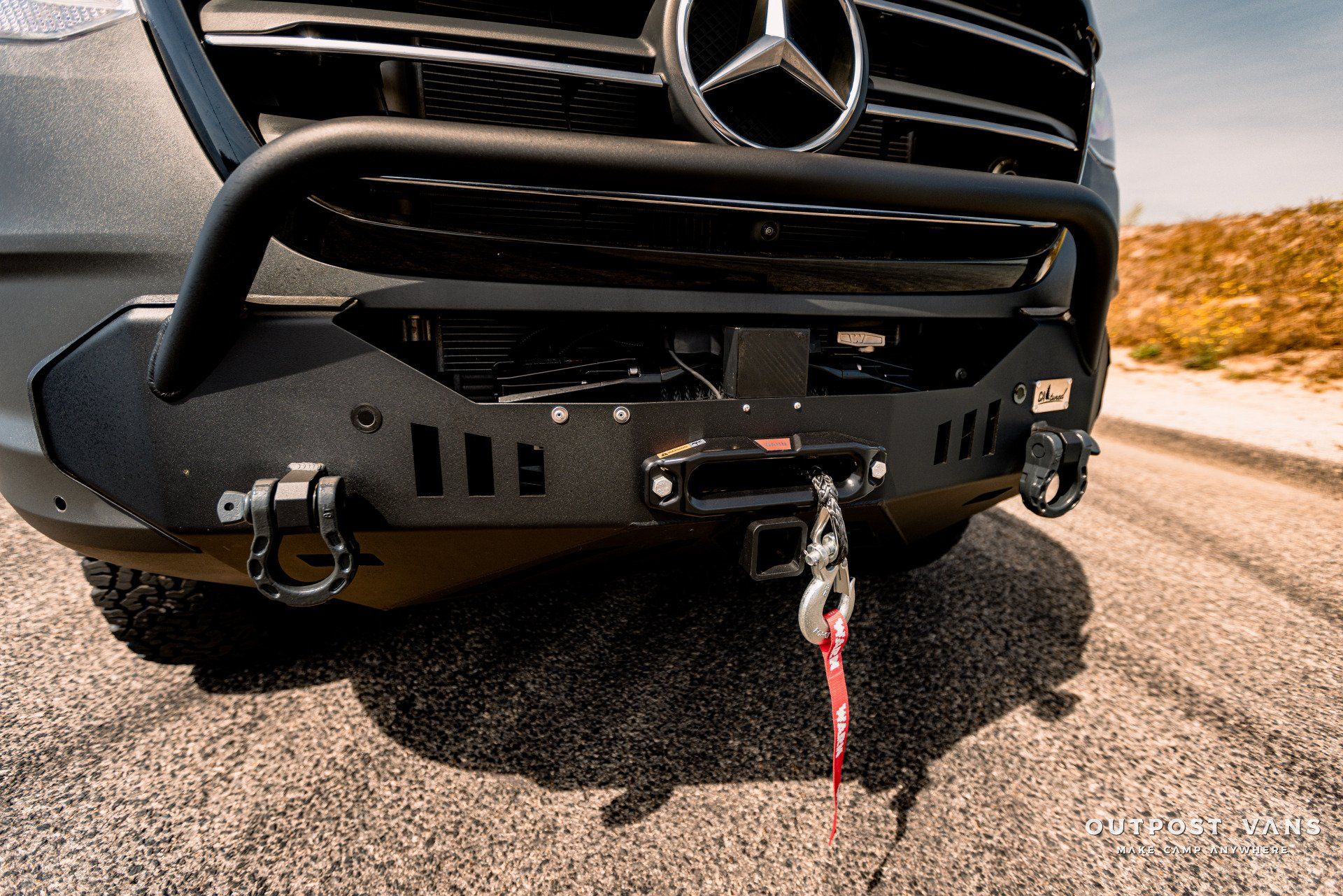 The front of a mercedes benz with a winch attached to it.