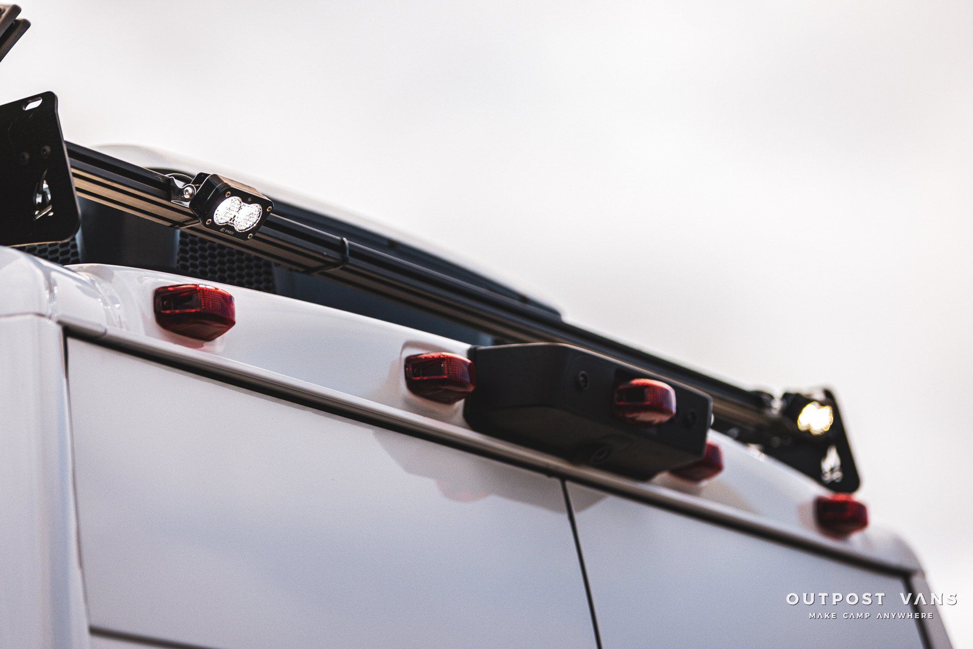 the back of a white van with red lights on it .