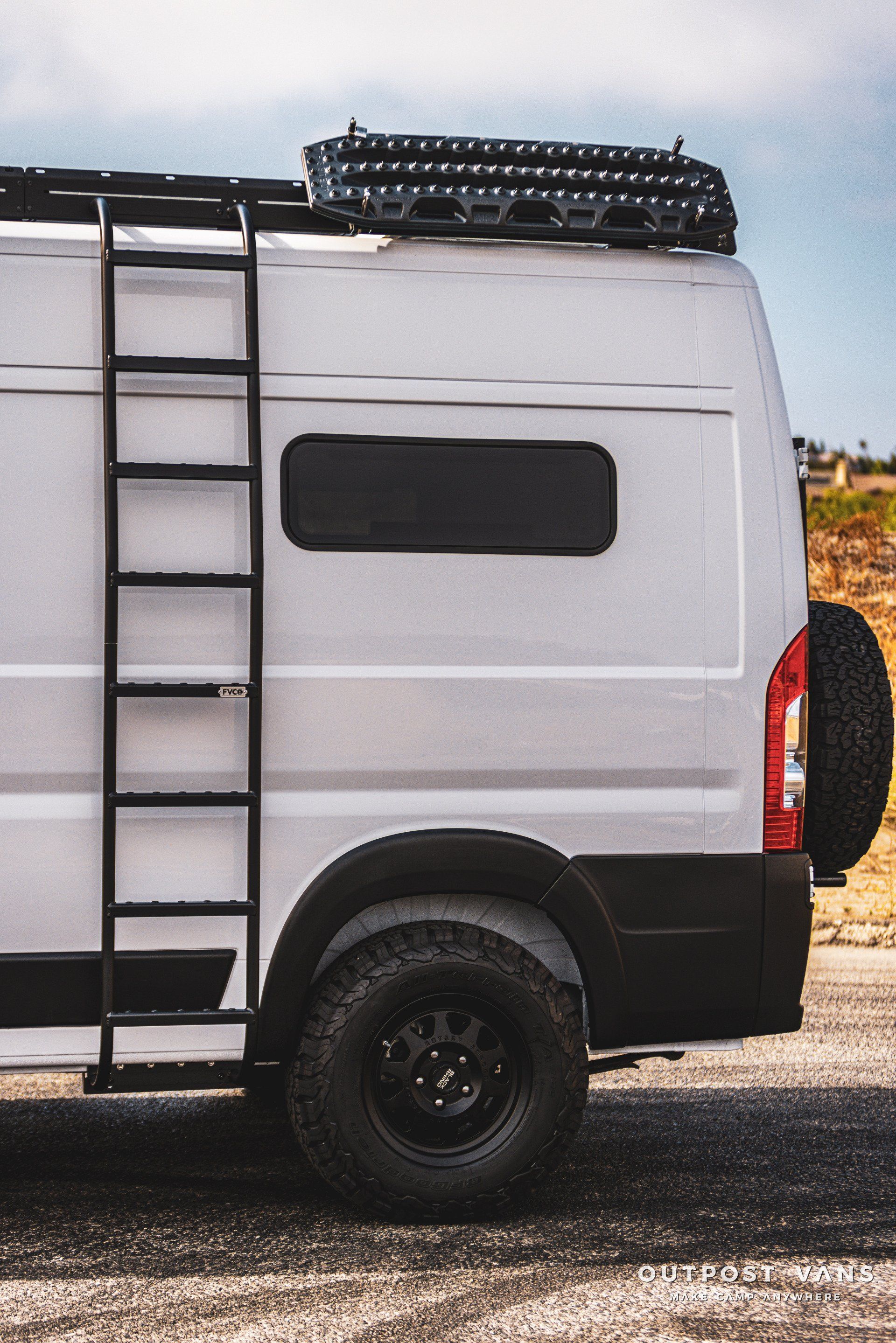 a white van with a ladder on the back is parked on the side of the road .