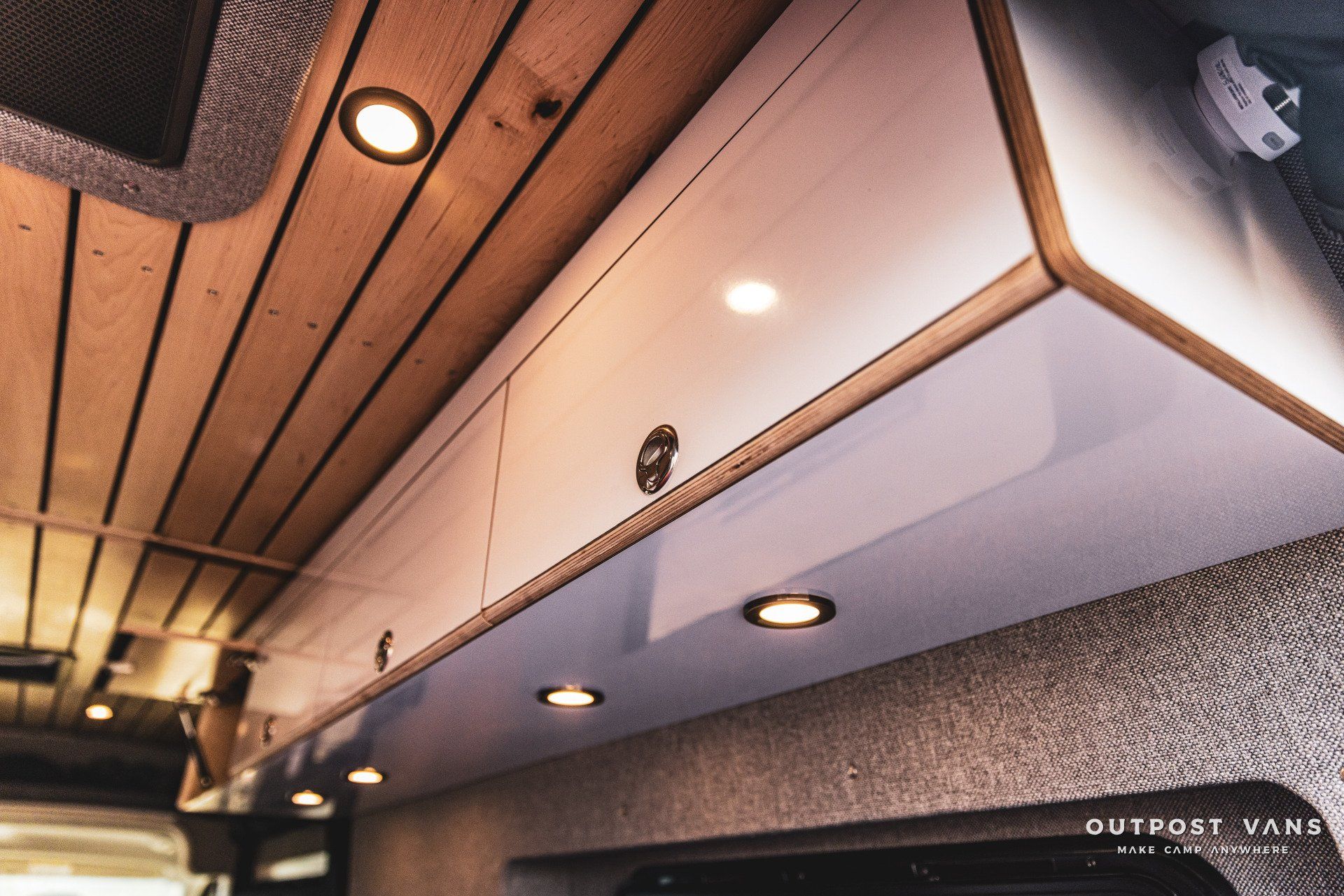 A van with a wooden ceiling and white cabinets