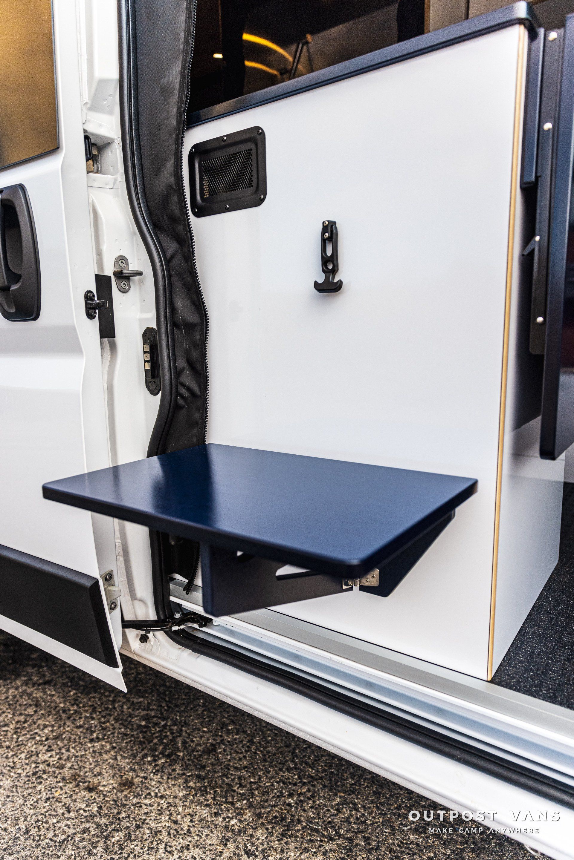 a white van with a blue table attached to the side of it .