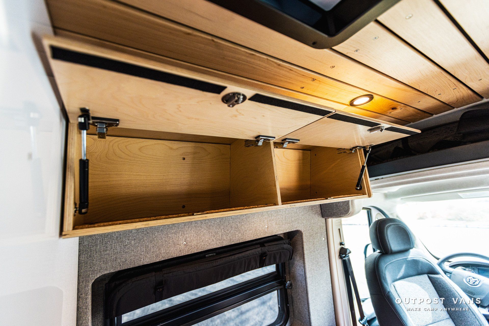 a van with a wooden shelf on the ceiling and a window .