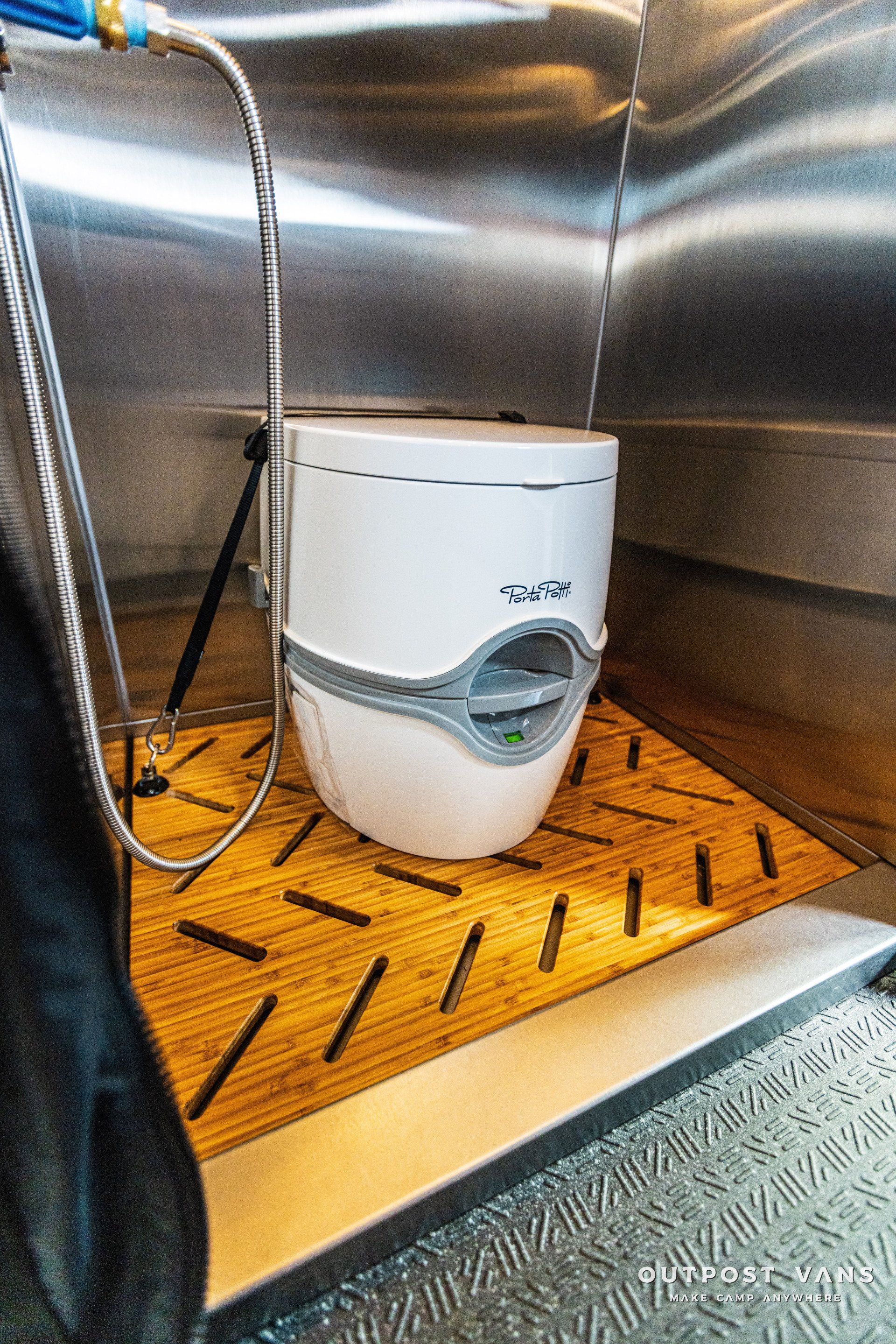 A white toilet is sitting on a wooden mat in a bathroom.