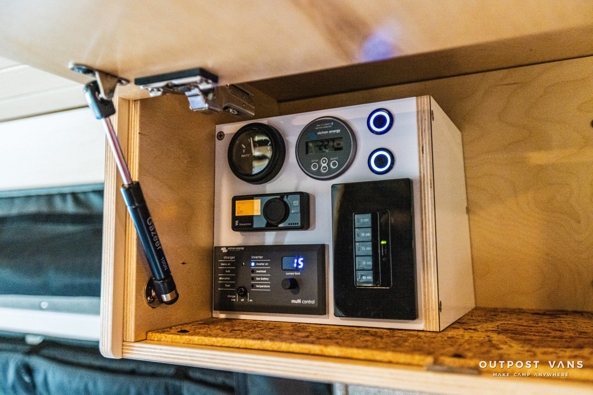 A wooden box with a bunch of electronic devices on it is sitting on top of a wooden shelf.
