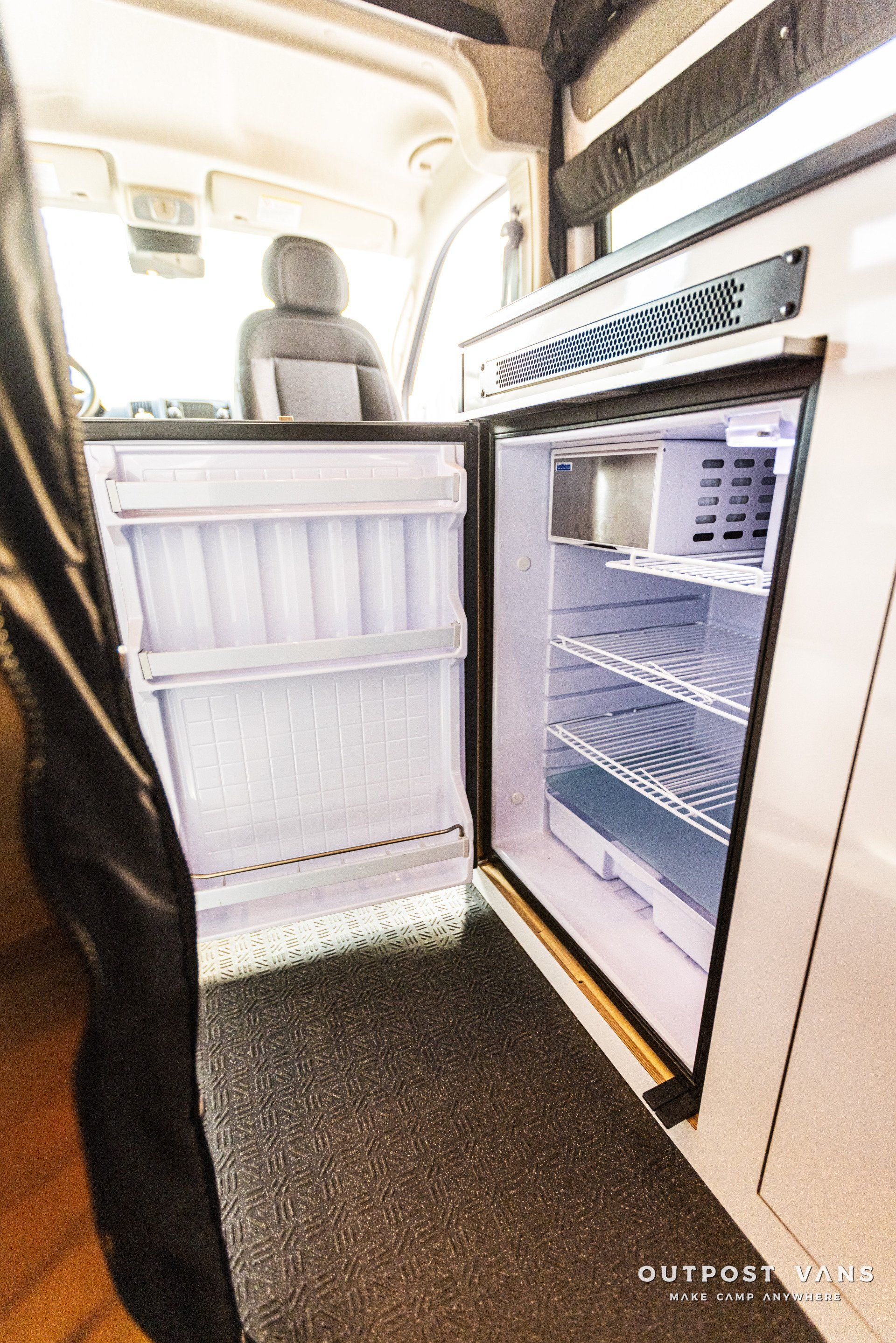 A small refrigerator is sitting in the back of a van.