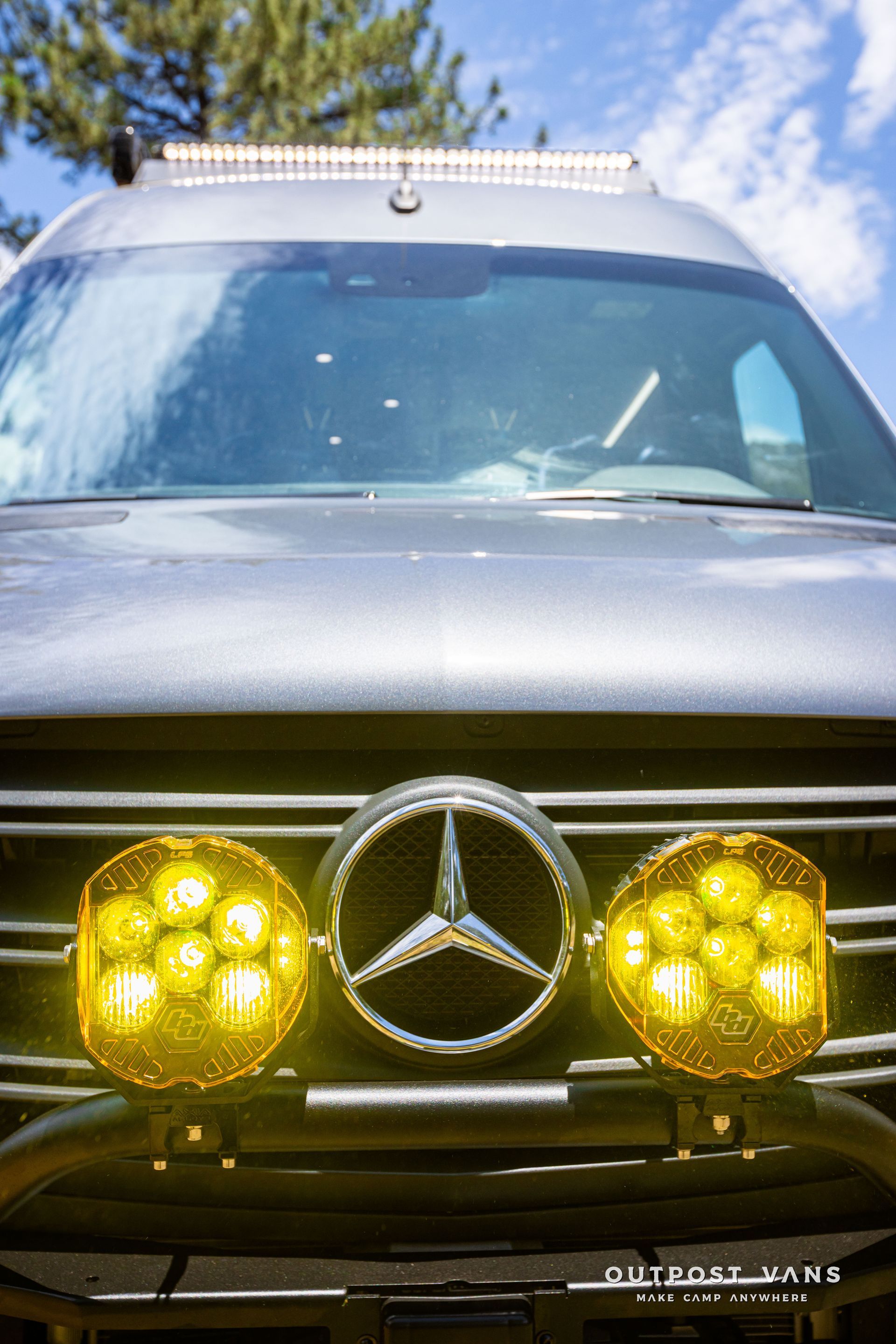 The front of a mercedes benz van with yellow lights on it. Outpost vans Sprinter 170 AWD.