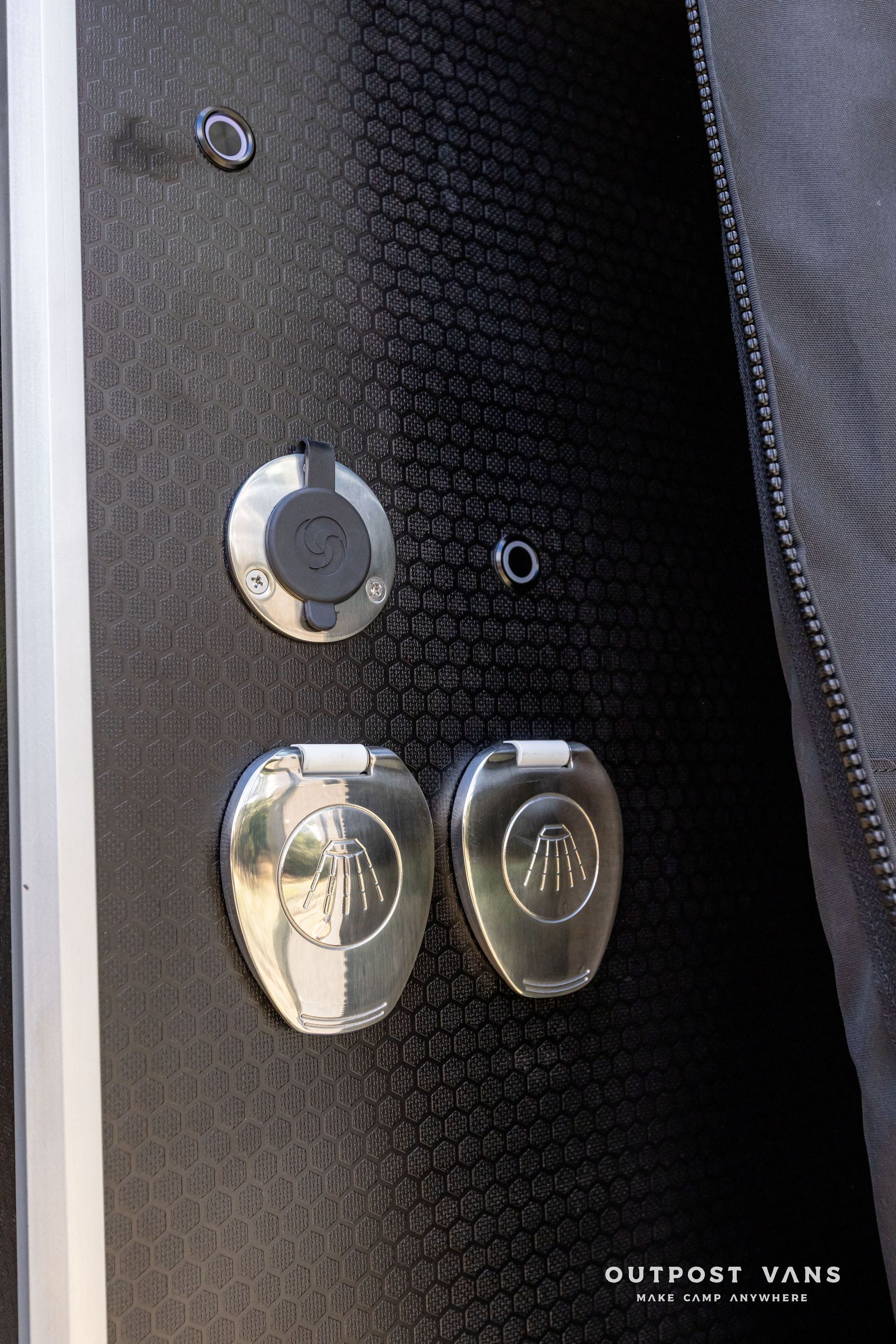 A close up of a door with a few buttons on it. Outpost vans Sprinter 170 AWD.