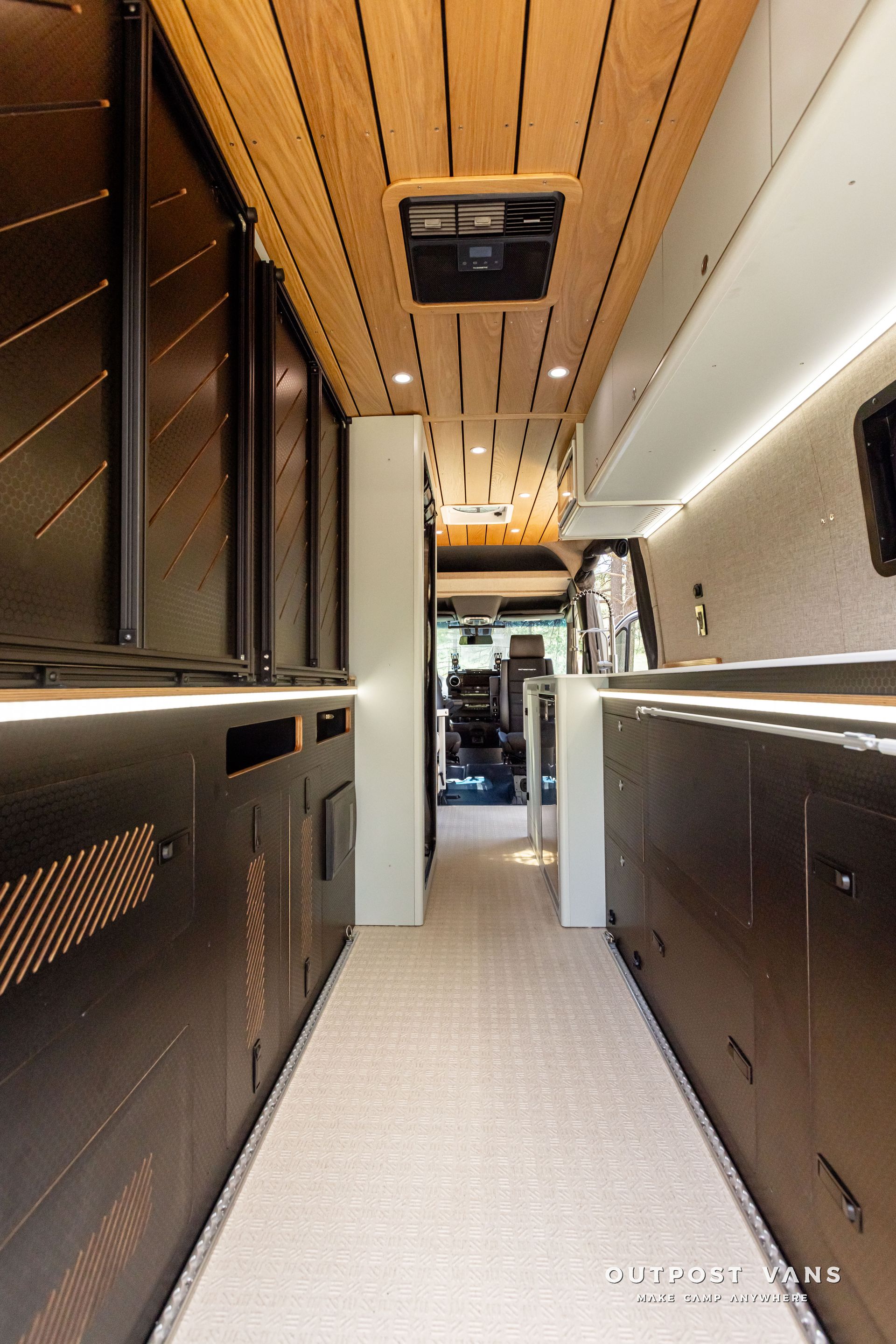A long hallway leading to a kitchen in a van Outpost vans Sprinter 170 AWD.