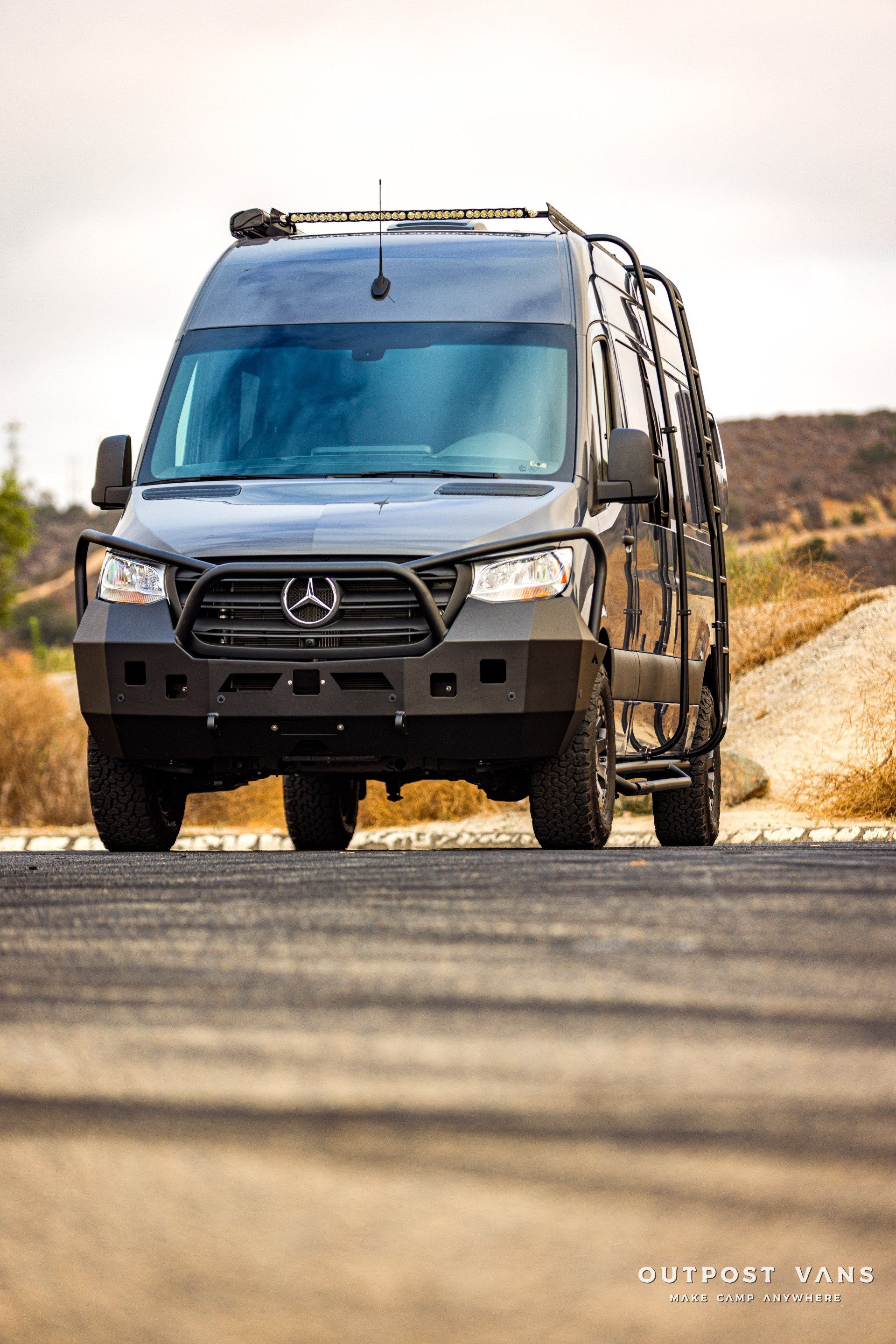A mercedes sprinter van is parked on the side of a road.