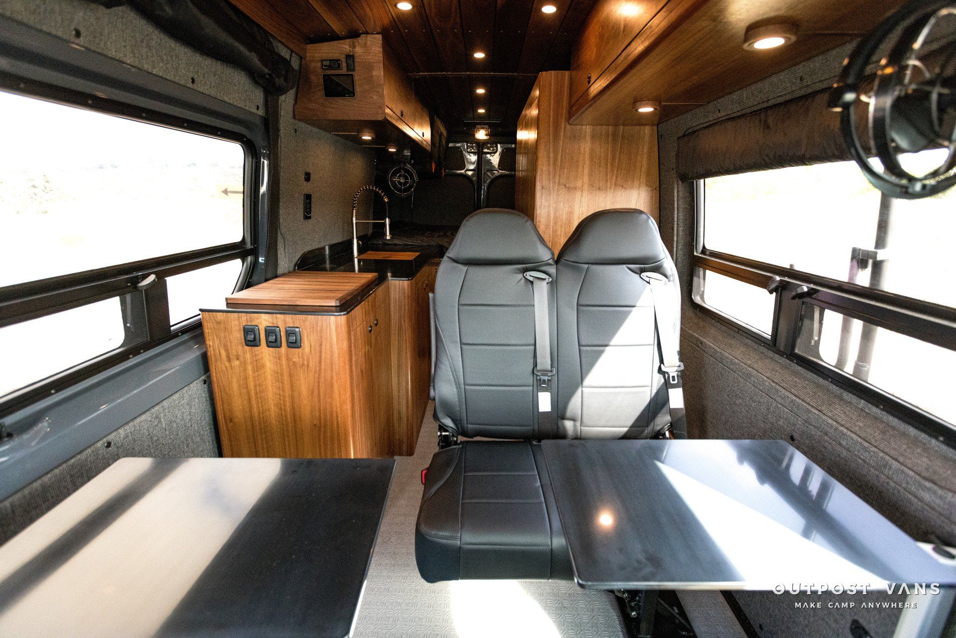 The inside of a van with two seats and a table.