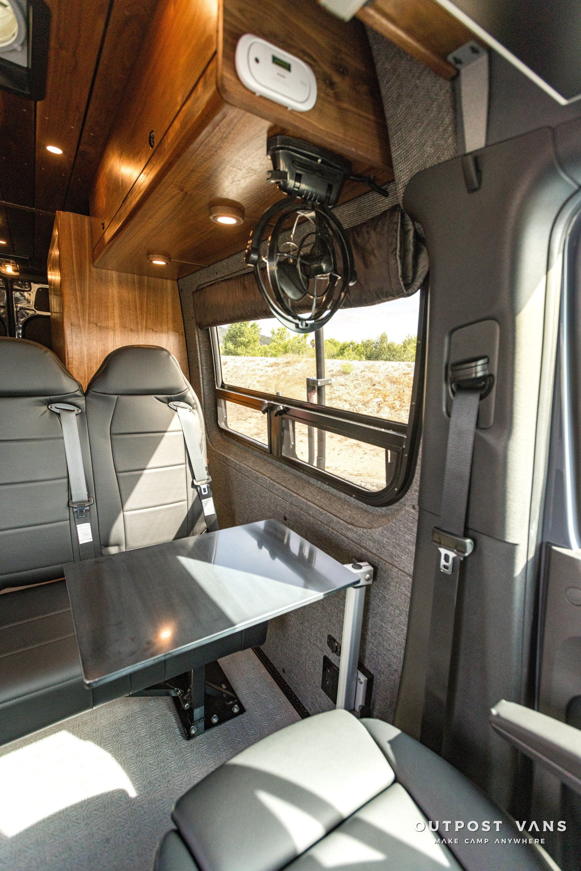 The inside of a van with a table and a fan.