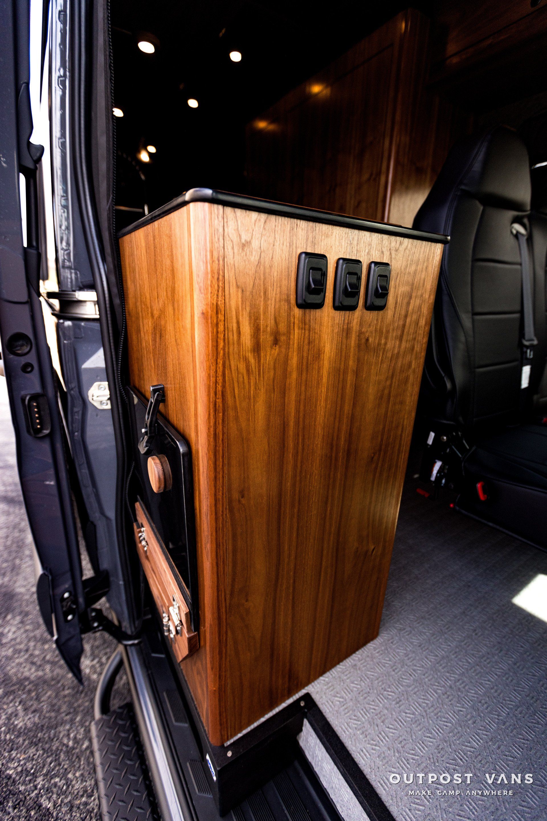 A wooden box is sitting in the back of a van.