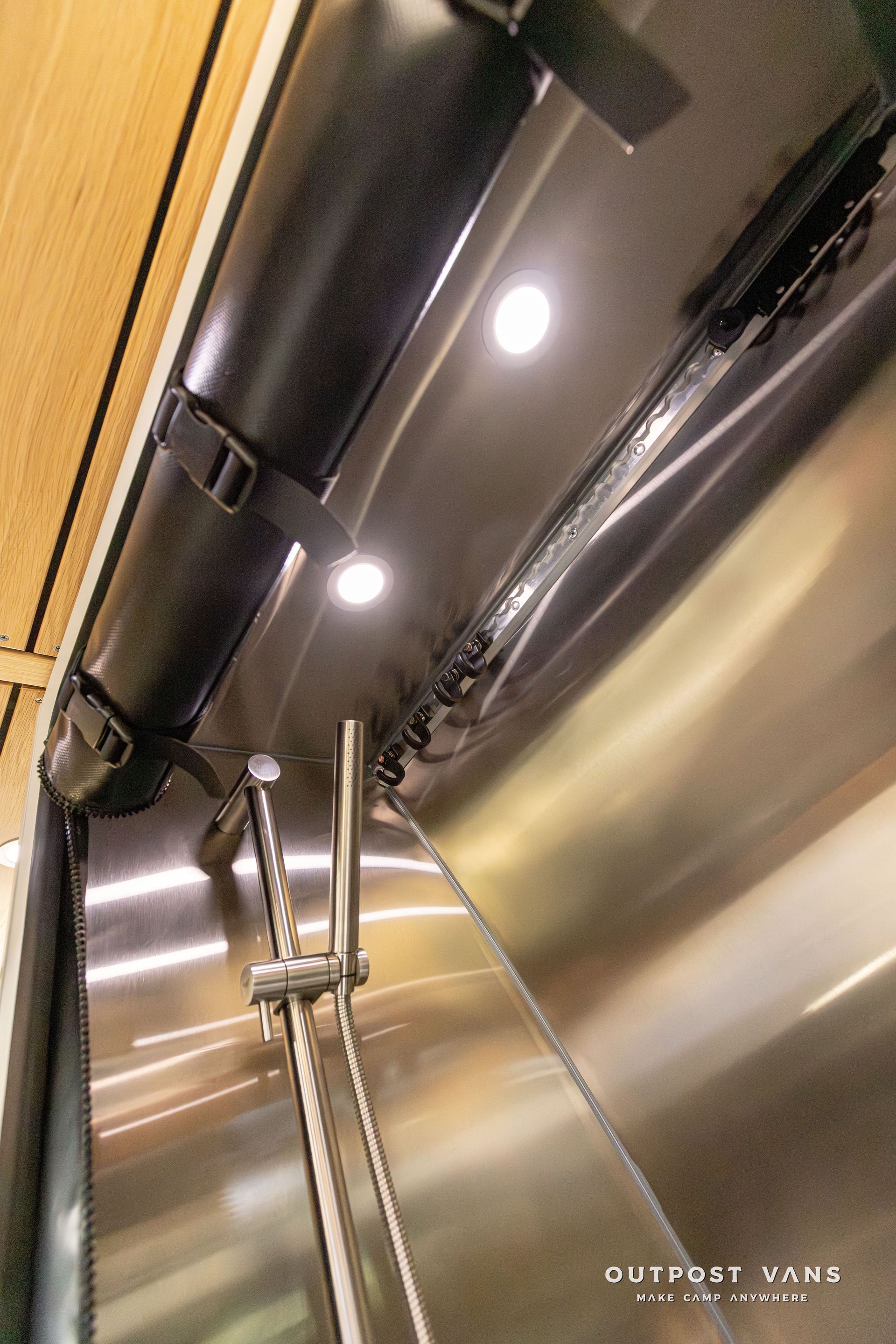 A ceiling fan is hanging from the ceiling of a stainless steel cabinet. Outpost vans Sprinter 170 AWD.