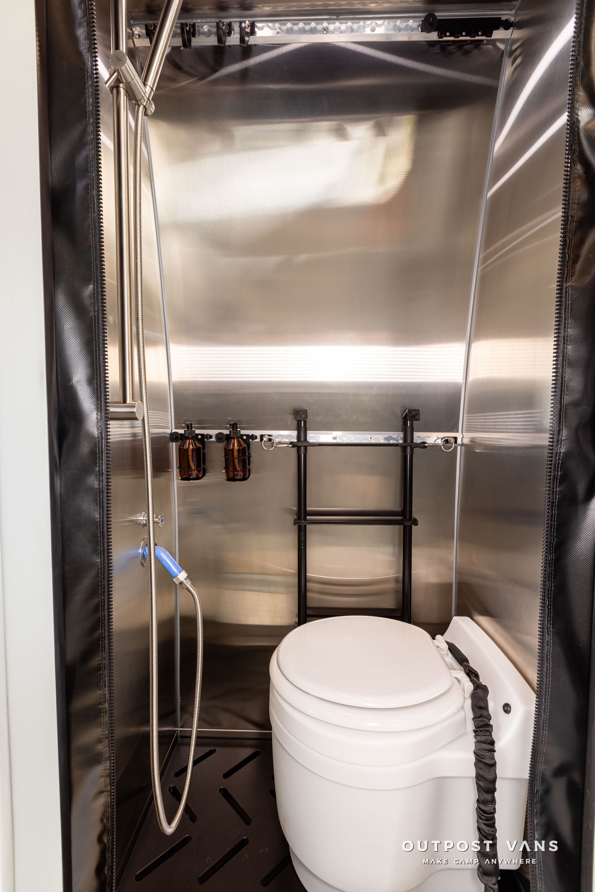 A bathroom with a toilet , shower and ladder. Outpost vans Sprinter 170 AWD.