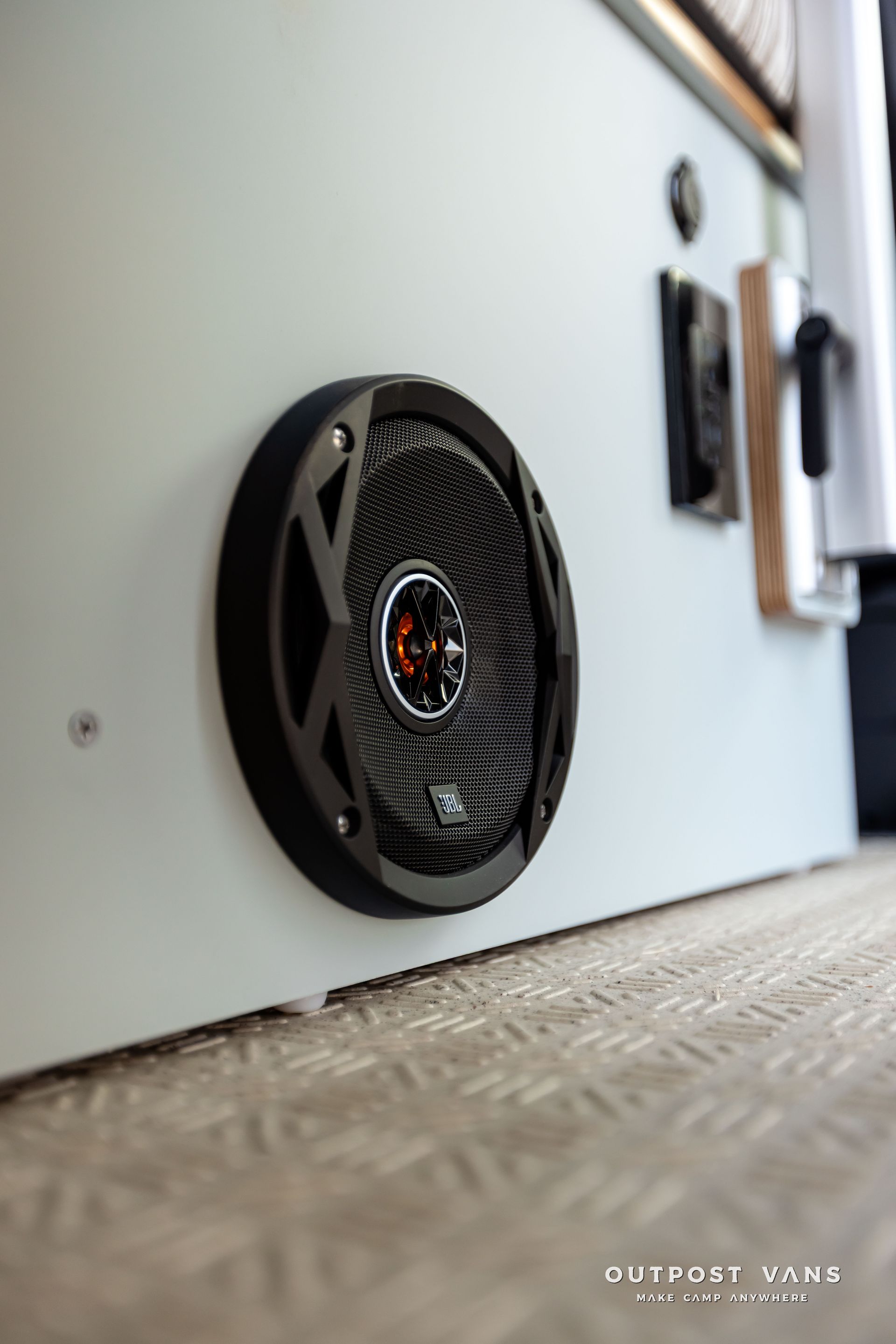 JBL speaker is mounted on the side of a white wall. Outpost vans Sprinter 170 AWD.