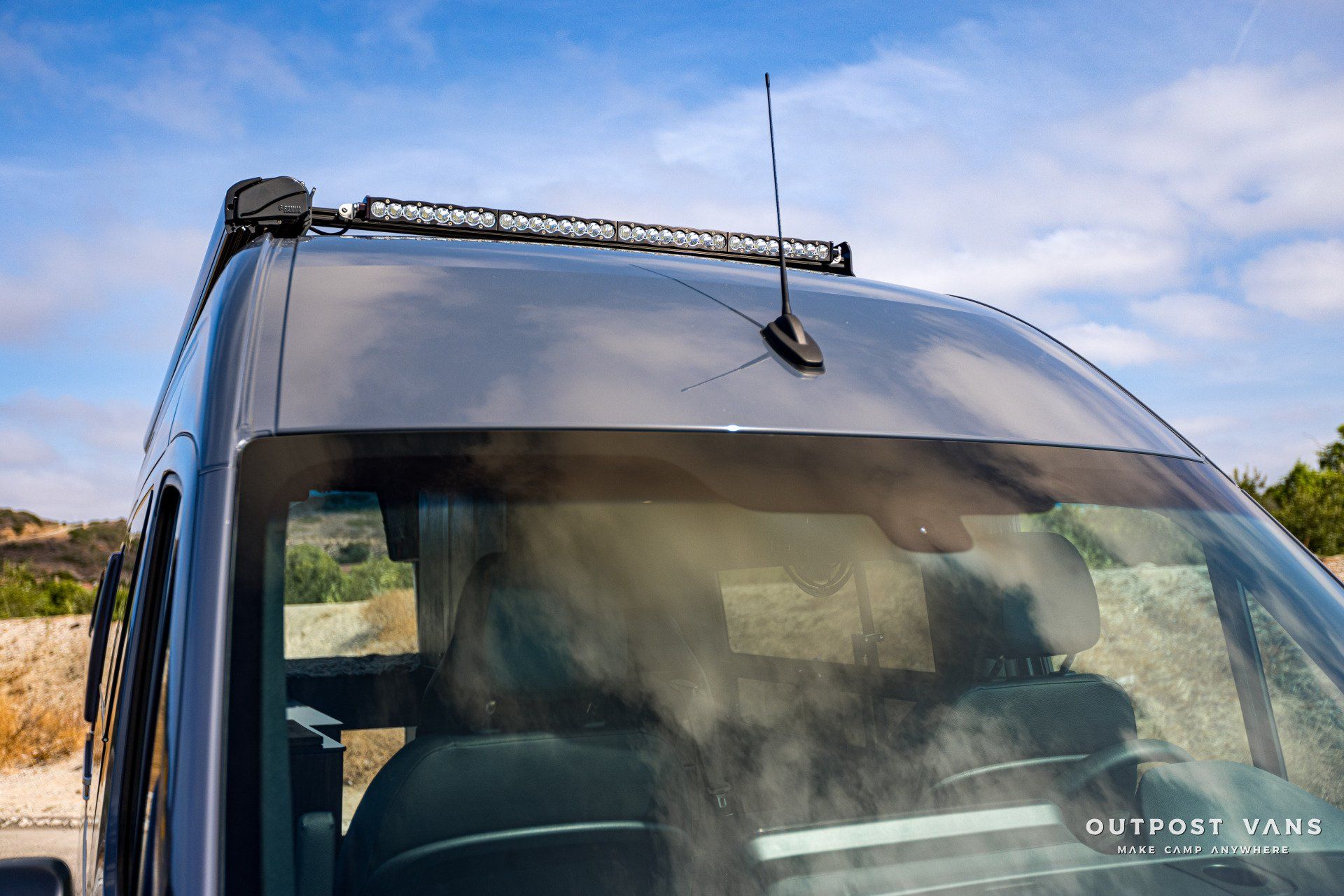 A van with a roof rack and antenna on top of it.