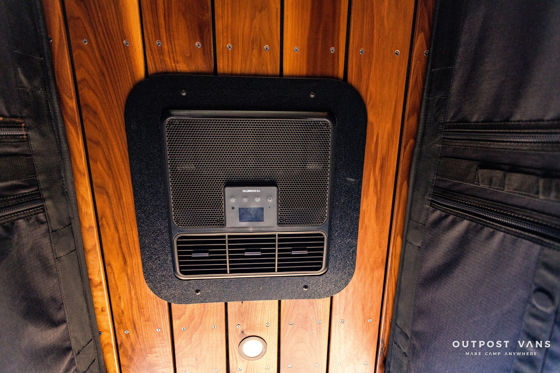 A fan is mounted to the ceiling of a wooden van.