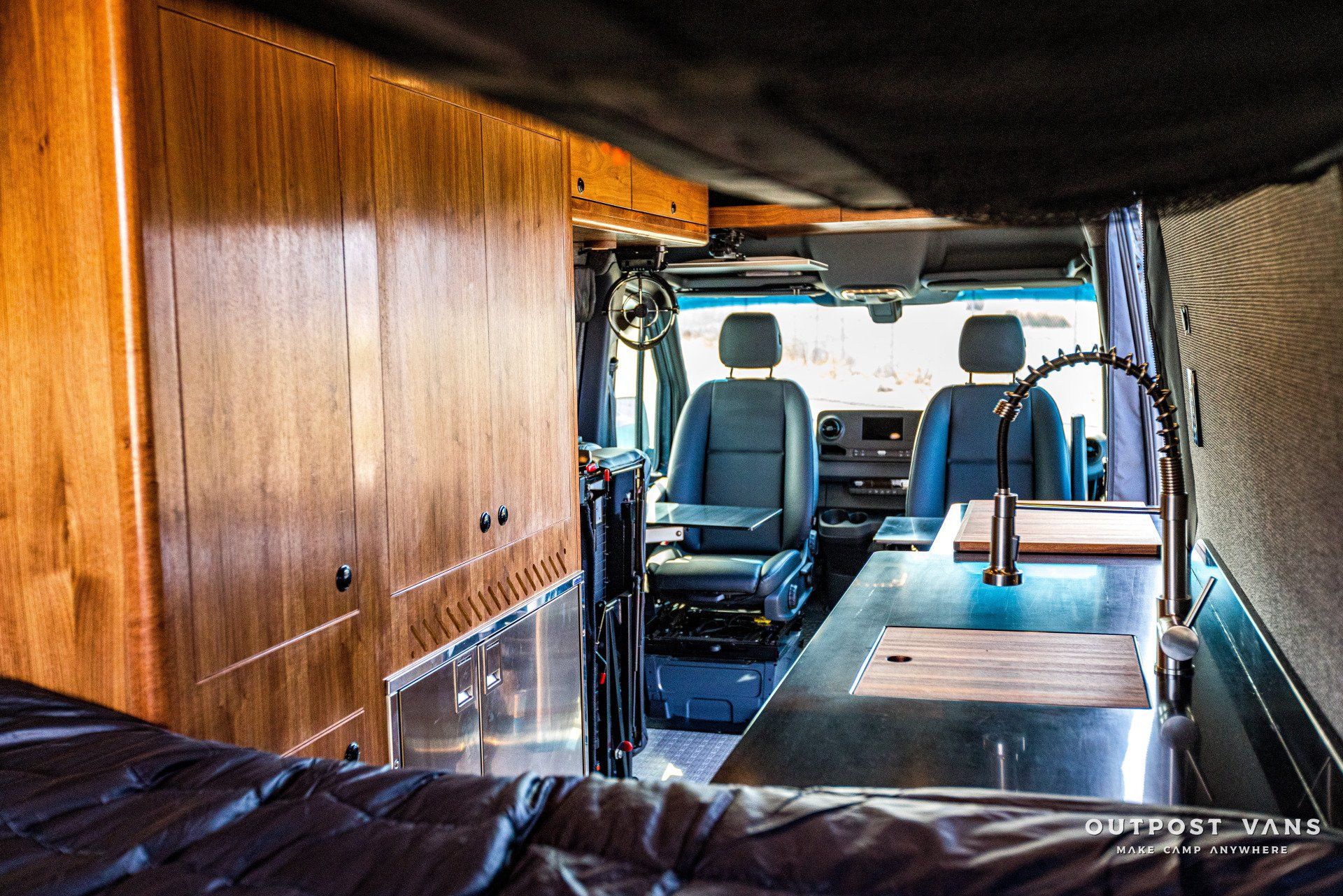 The inside of a van with a sink and cabinets