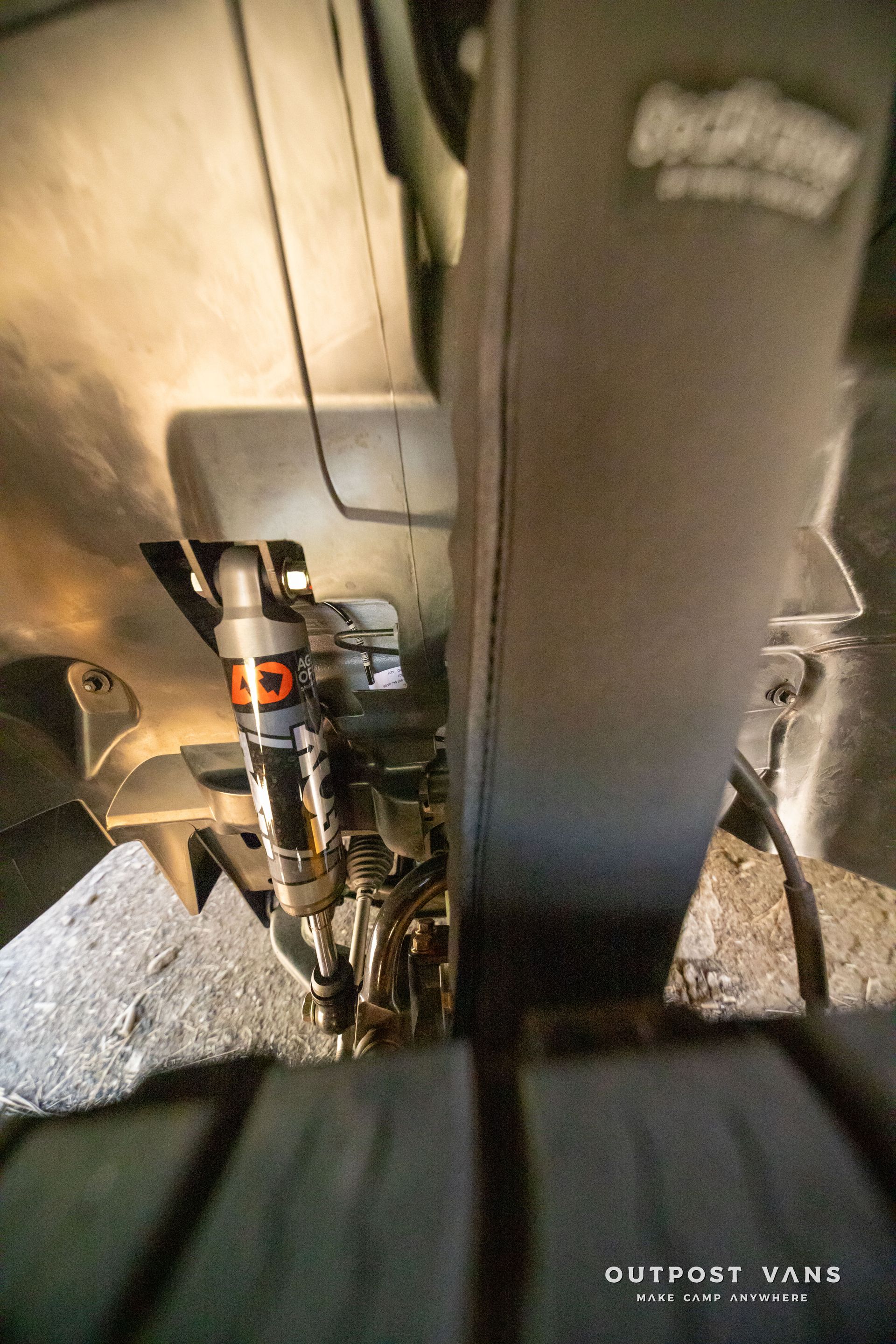 Sprinter Black suspension components, with orange accents, are viewed from below a vehicle. agile offroad