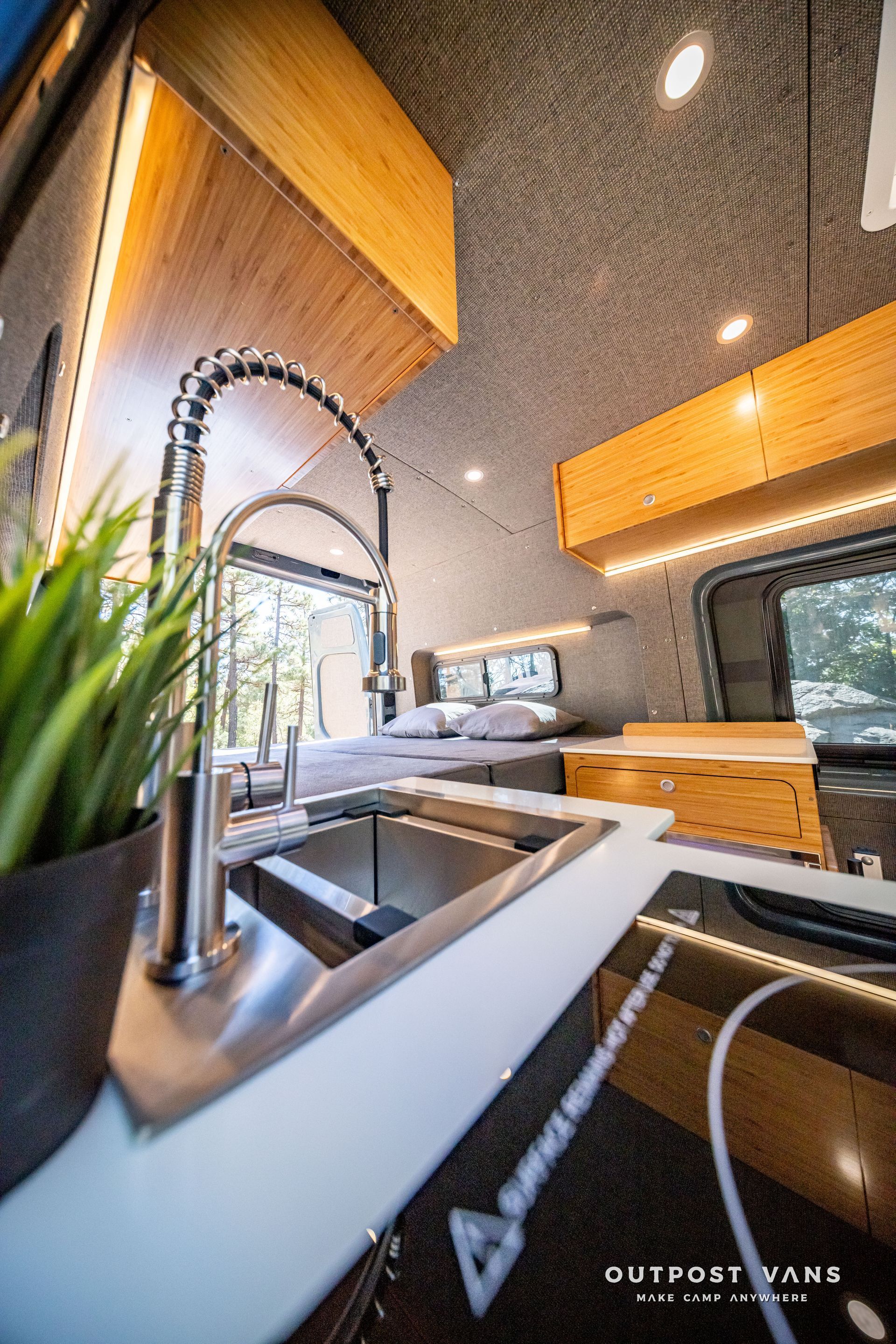 Sprinter Interior view of a van kitchen with a sink and wooden accents.