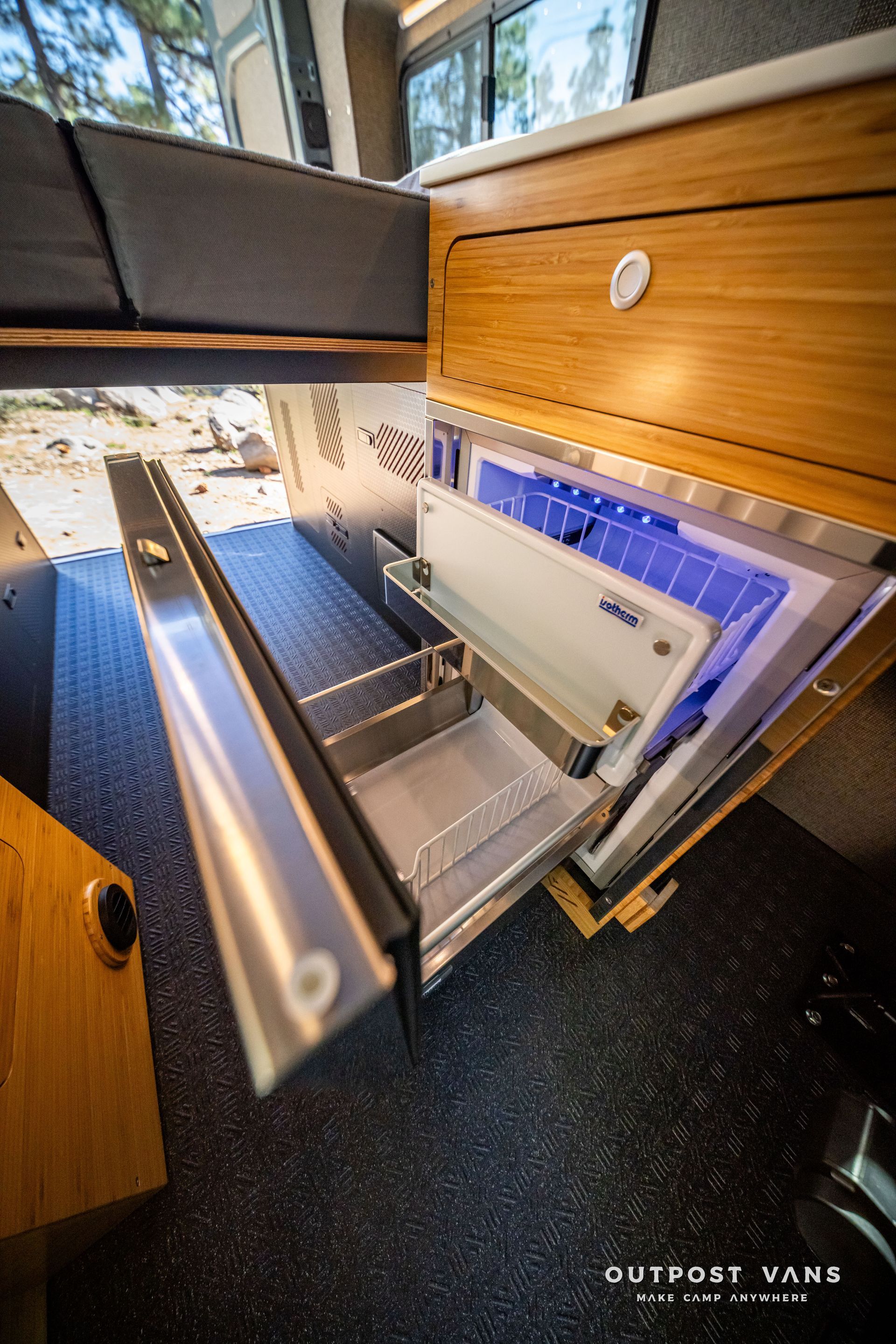 Sprinter Interior of a van with an open refrigerator. Silver interior and a wooden drawer.