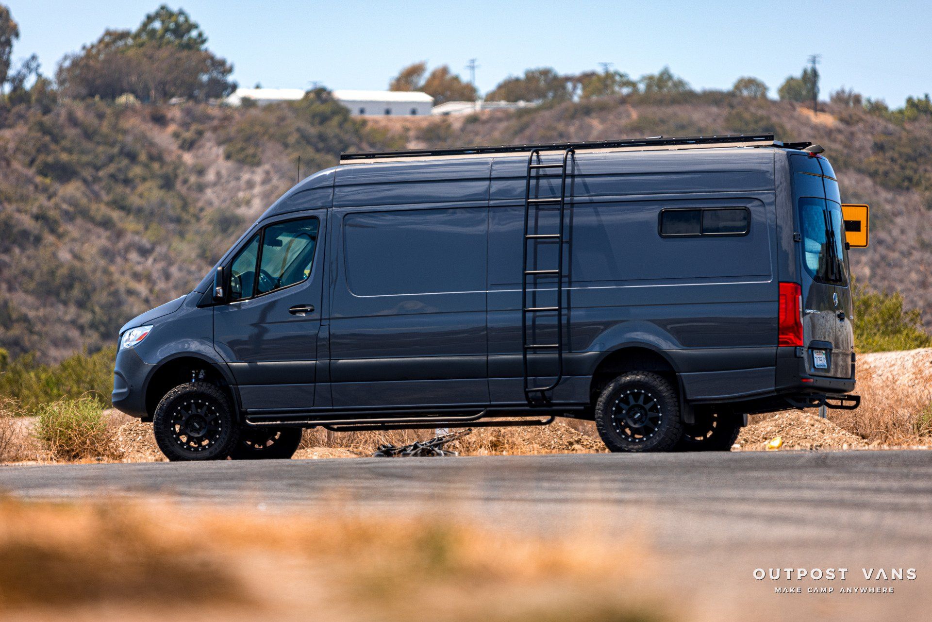 A gray van is parked on the side of a road.