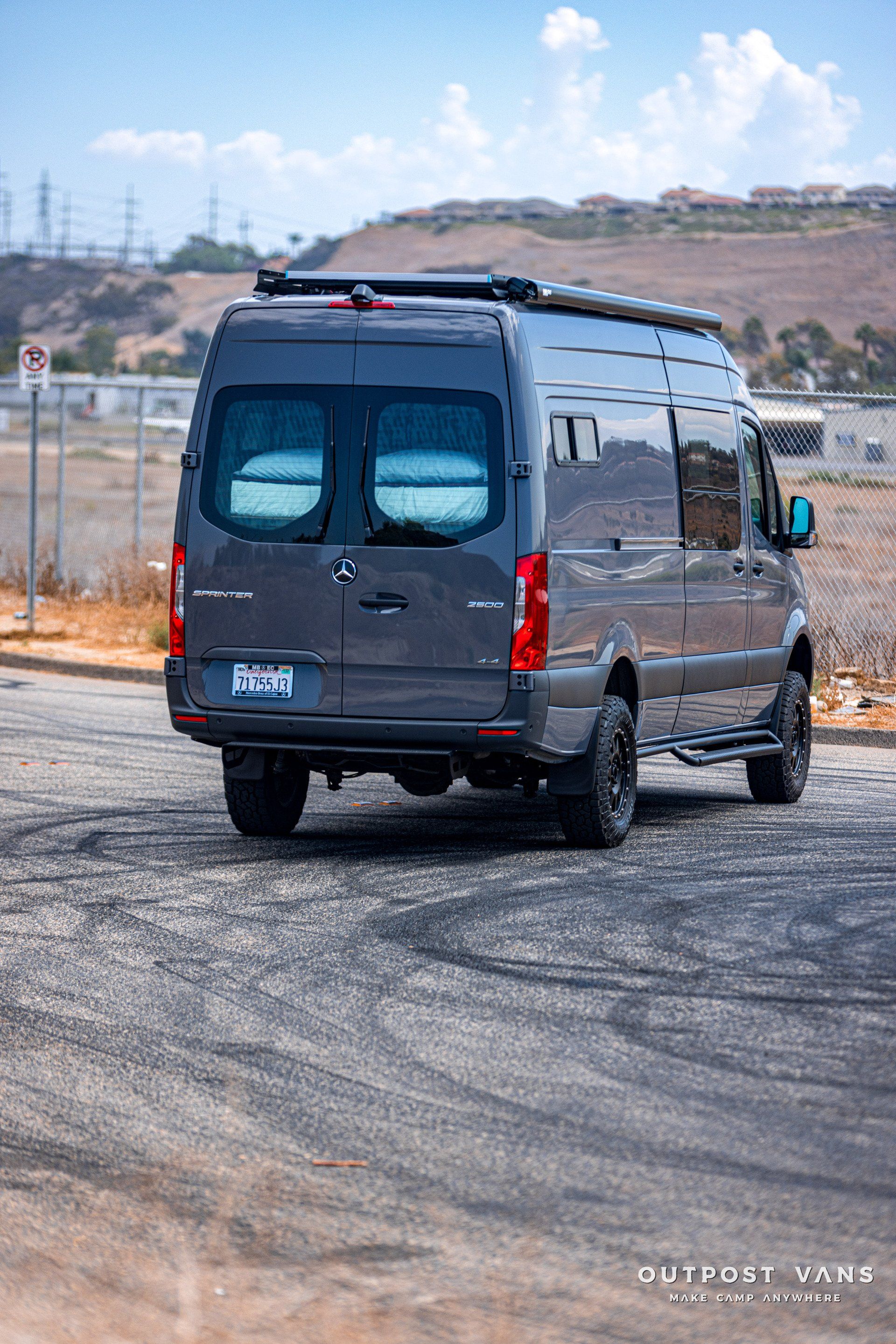 A mercedes benz sprinter van is parked in a parking lot.