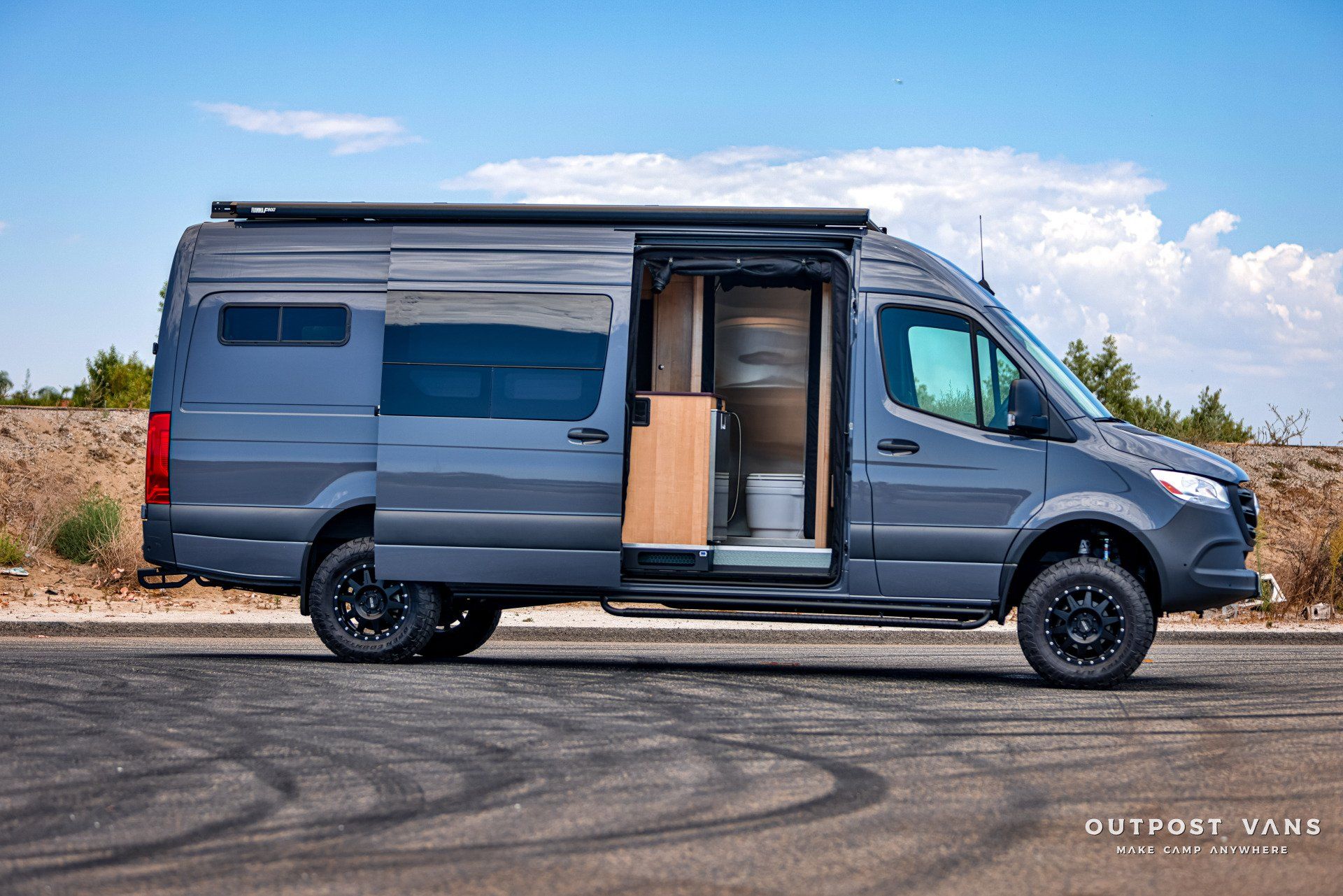 A gray van is parked on the side of the road.