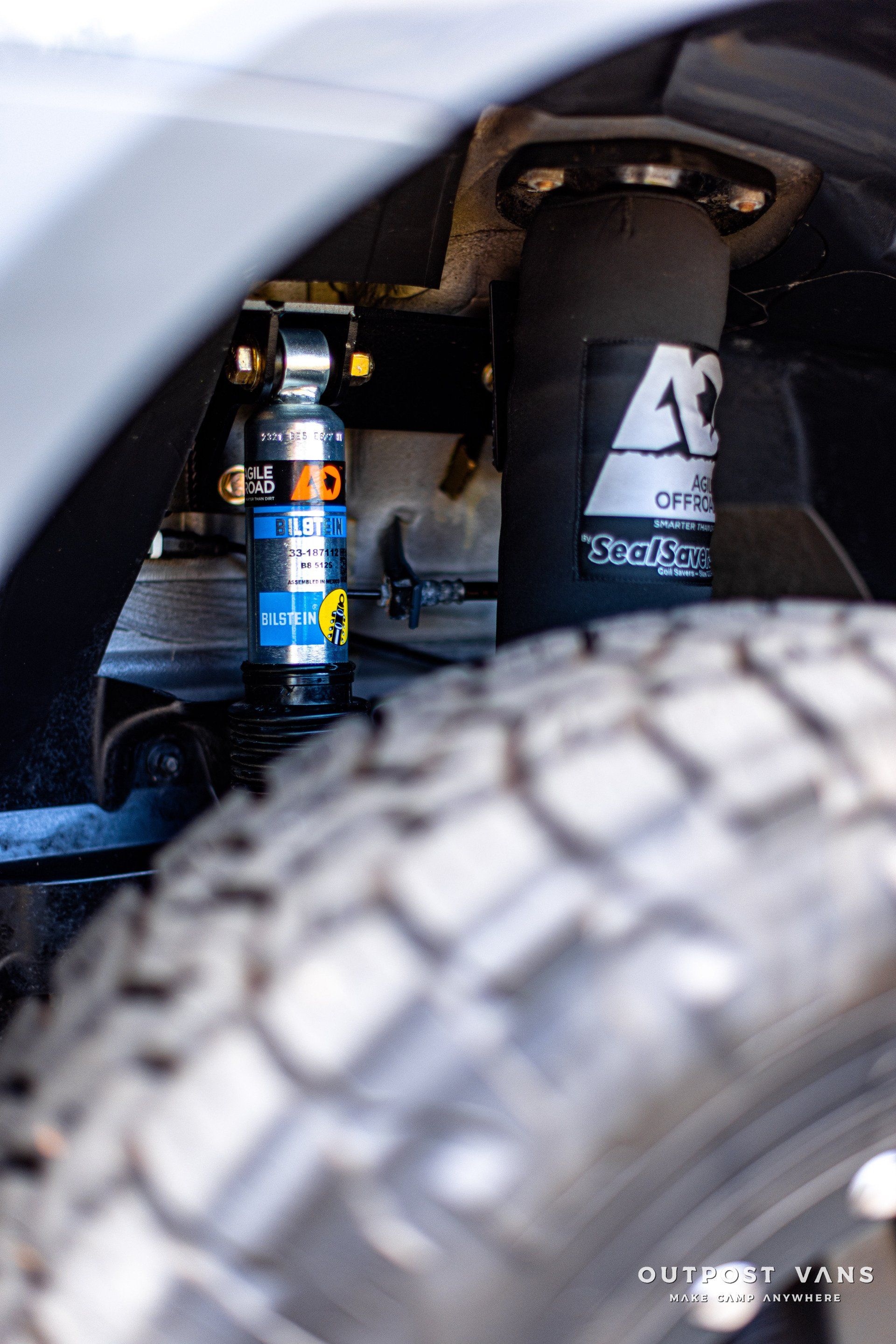 A close up of a tire and shock absorber on a car.