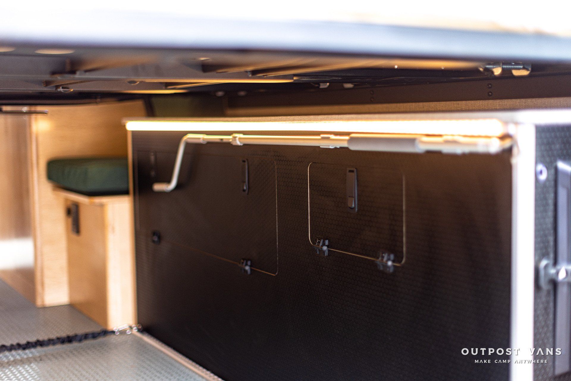 a black box with a handle on it is sitting under a table .