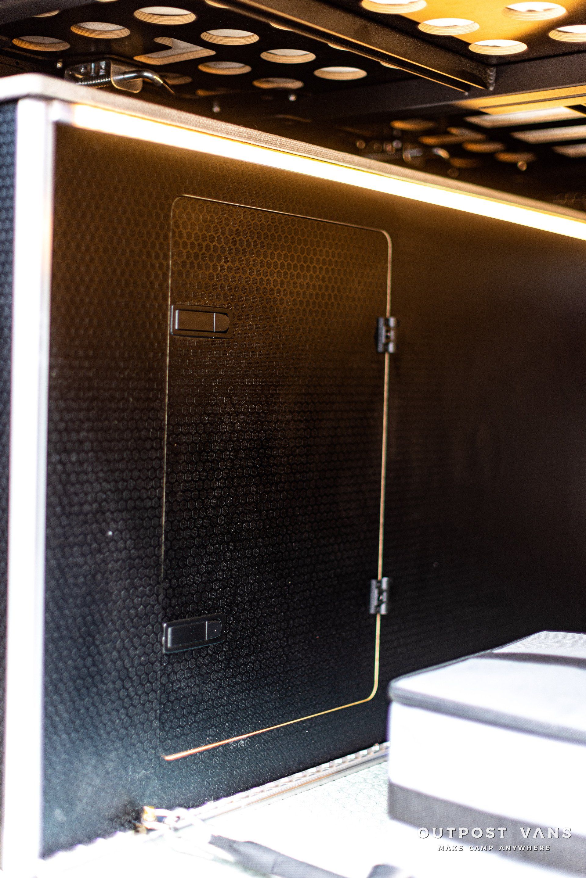 a black wall with a door and a light on it .