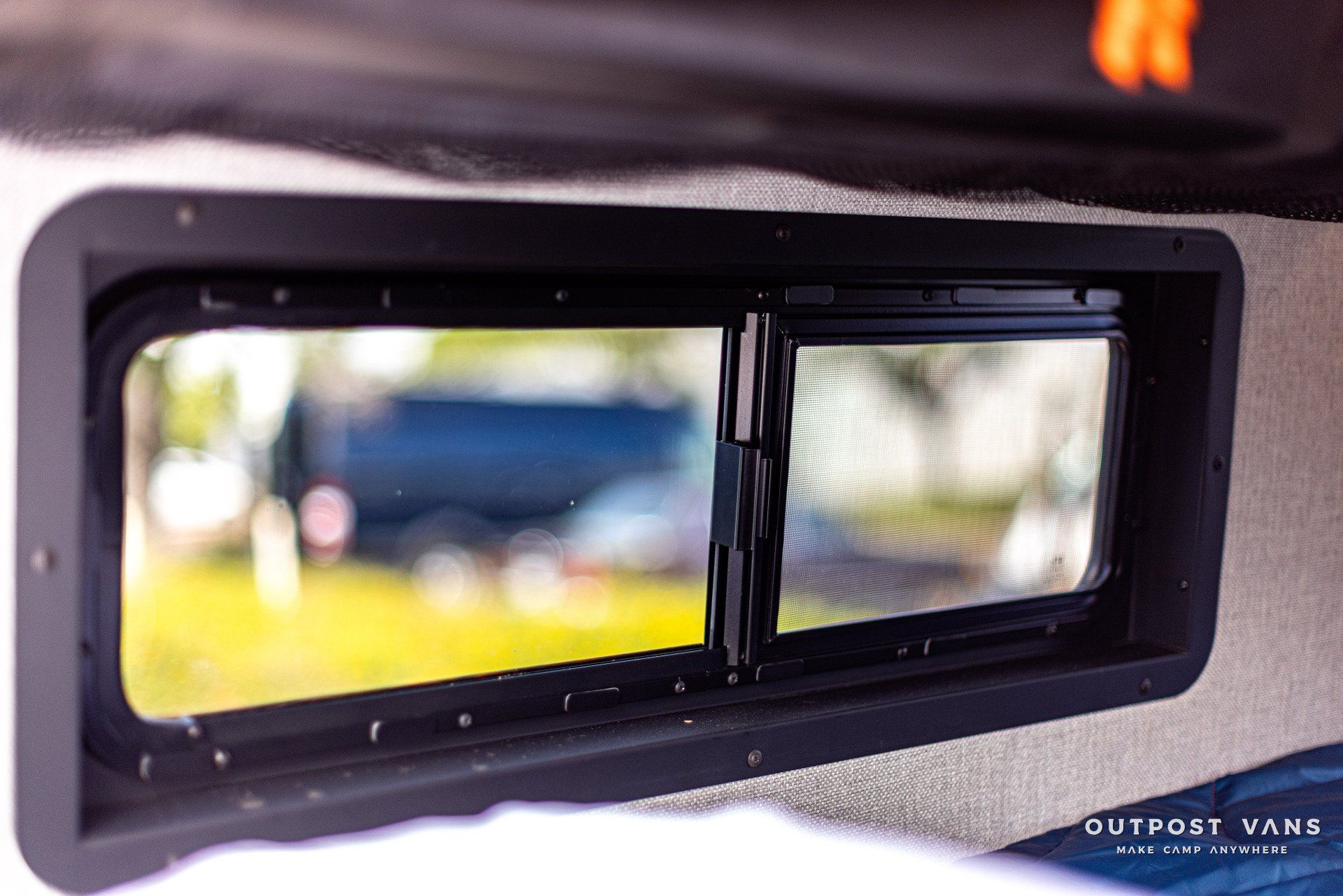 a window in a van with a reflection of a truck in it .
