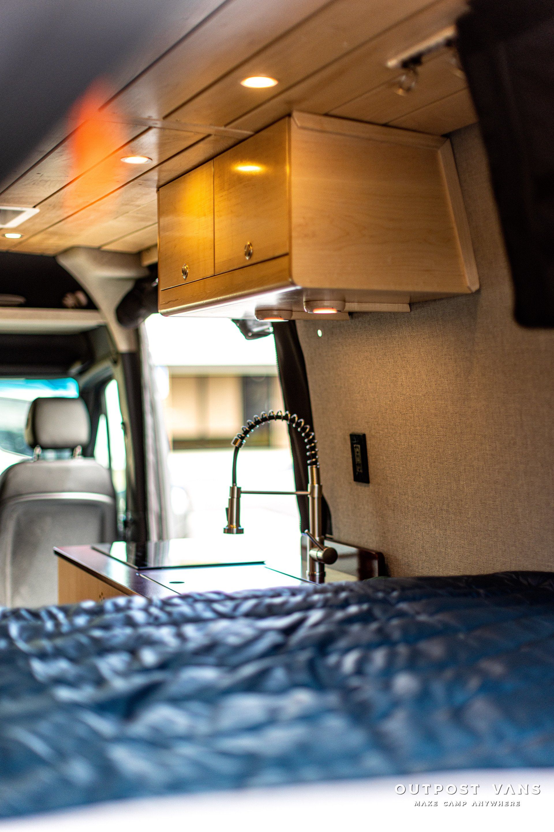 A van with a bed and a sink in it
