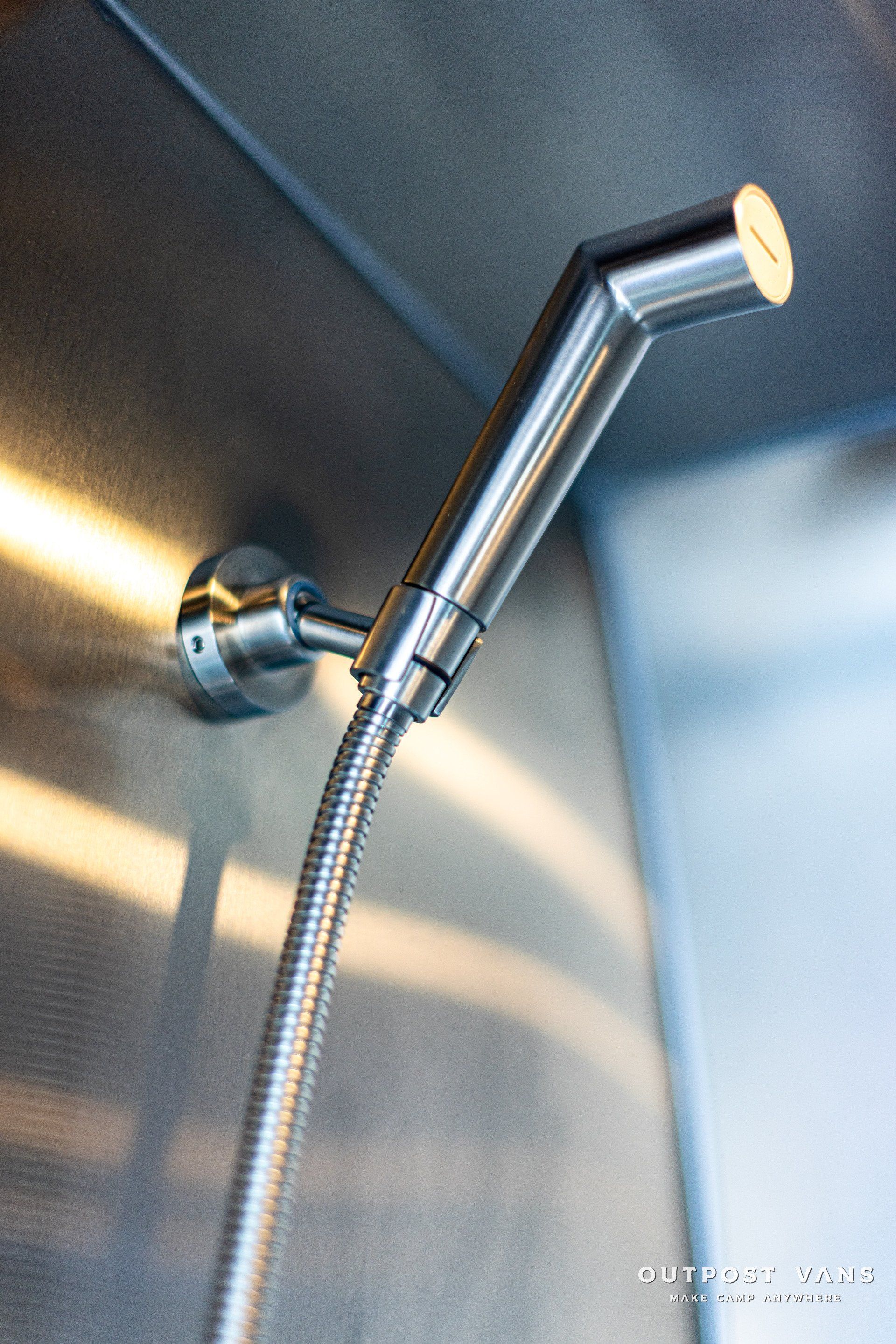 A stainless steel shower head with a hose attached to it
