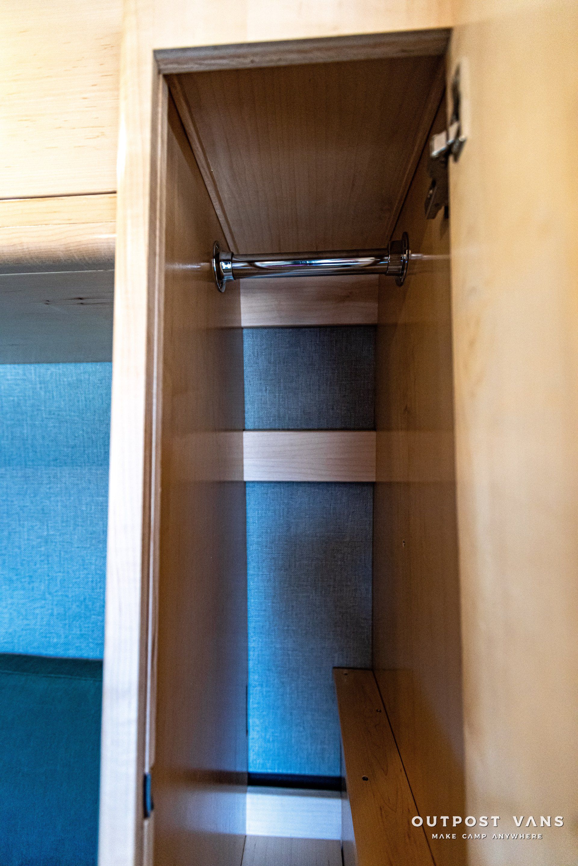 An empty closet with a metal railing and a shelf.