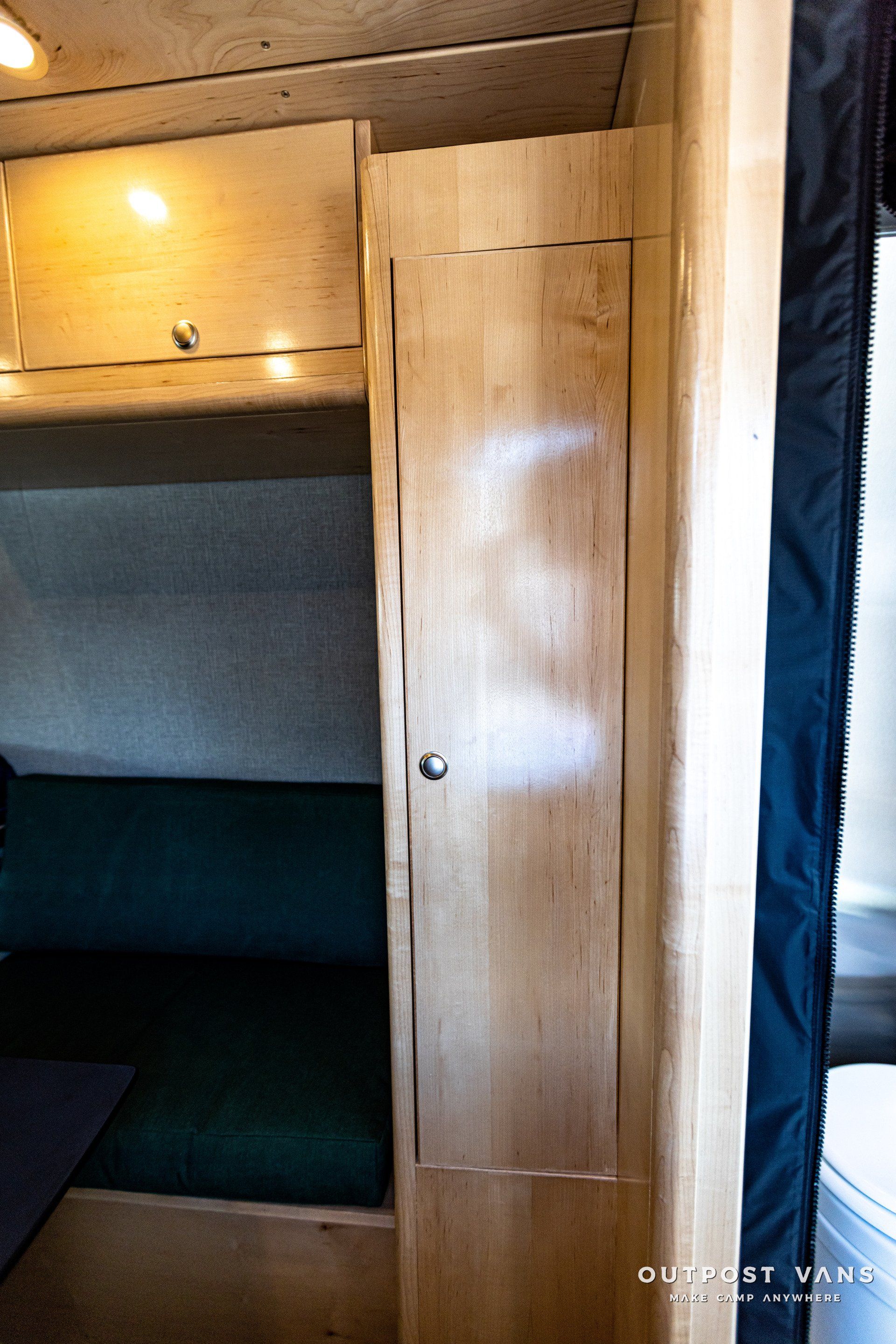 A wooden door in a room with a couch and a toilet.