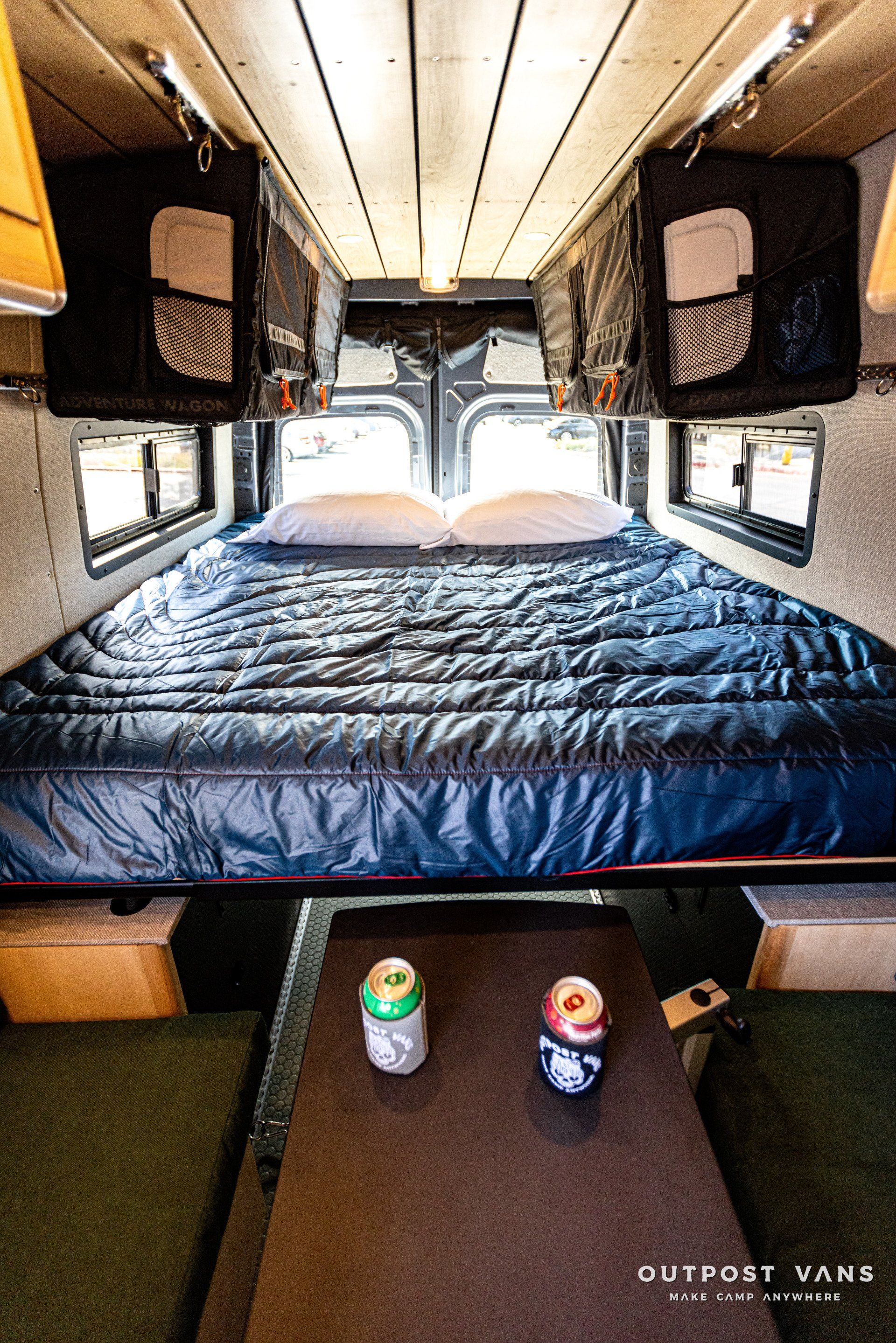 the inside of a van with a bed and a table .