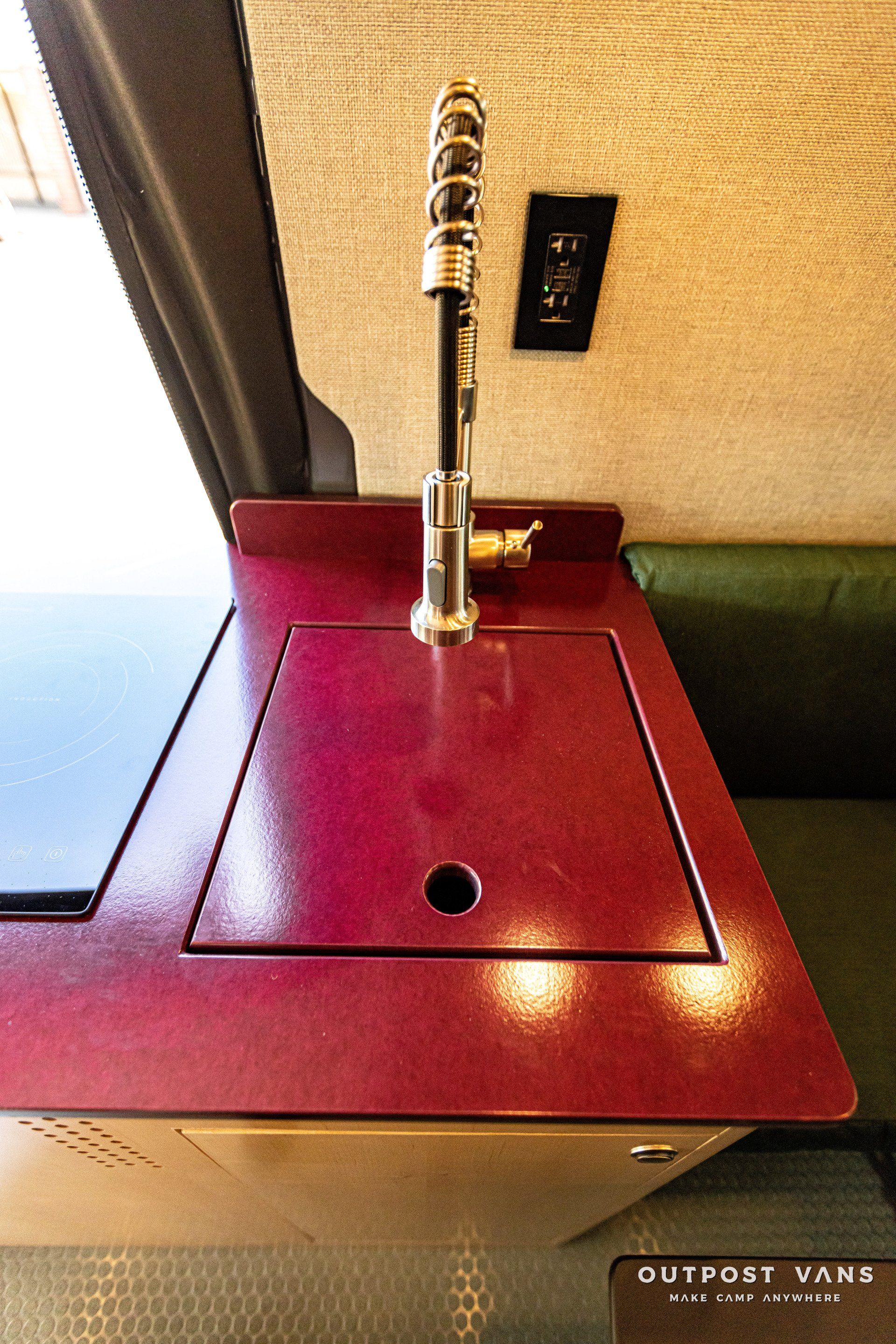 A red counter top with a sink and a faucet