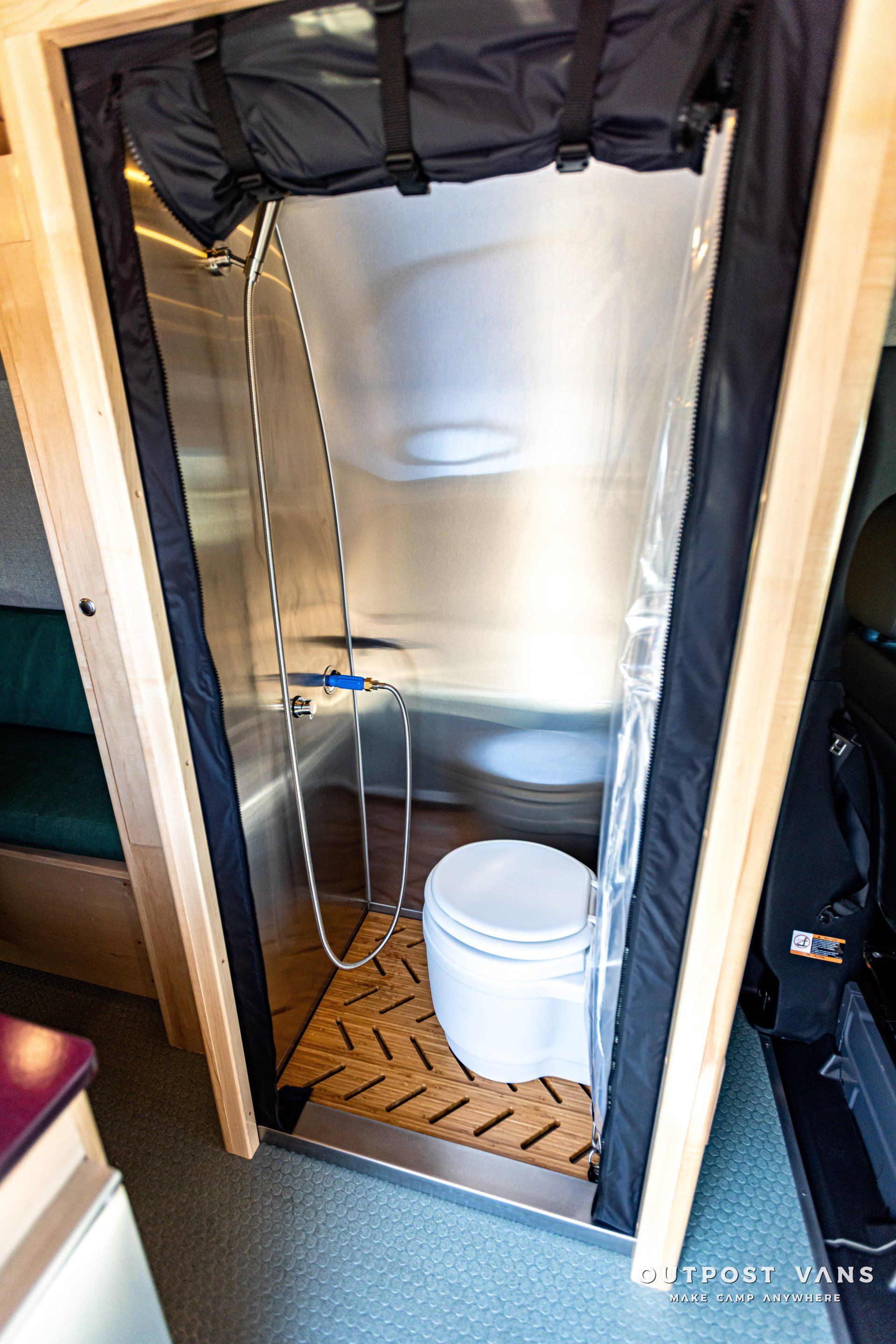 A bathroom in a camper van with a toilet and shower.